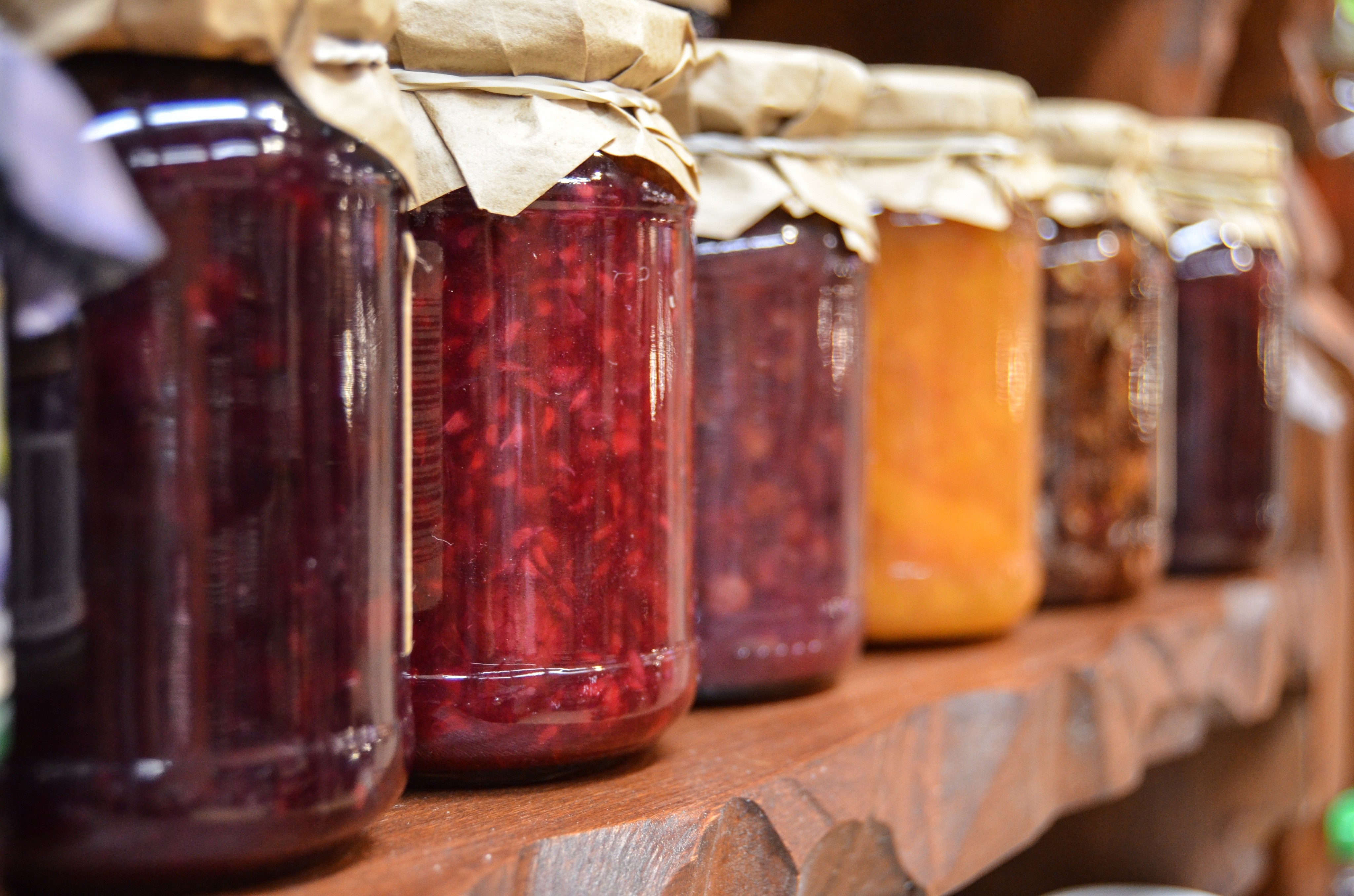 Jars of homemade preserves on a wooden shelf HD Wallpaper