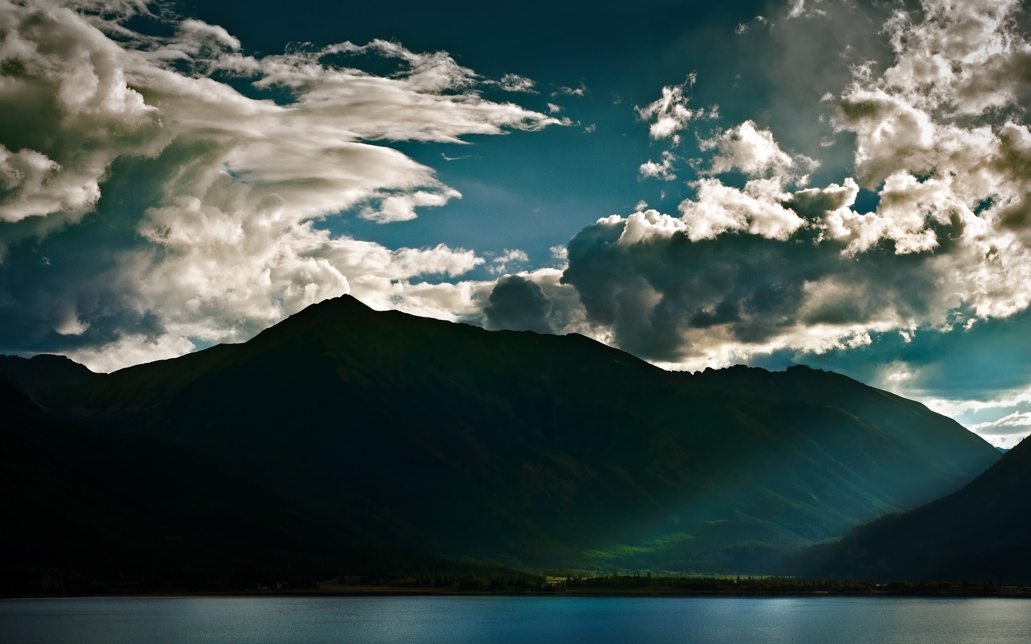 Mountain range over a lake under a cloudy sky HD Wallpaper