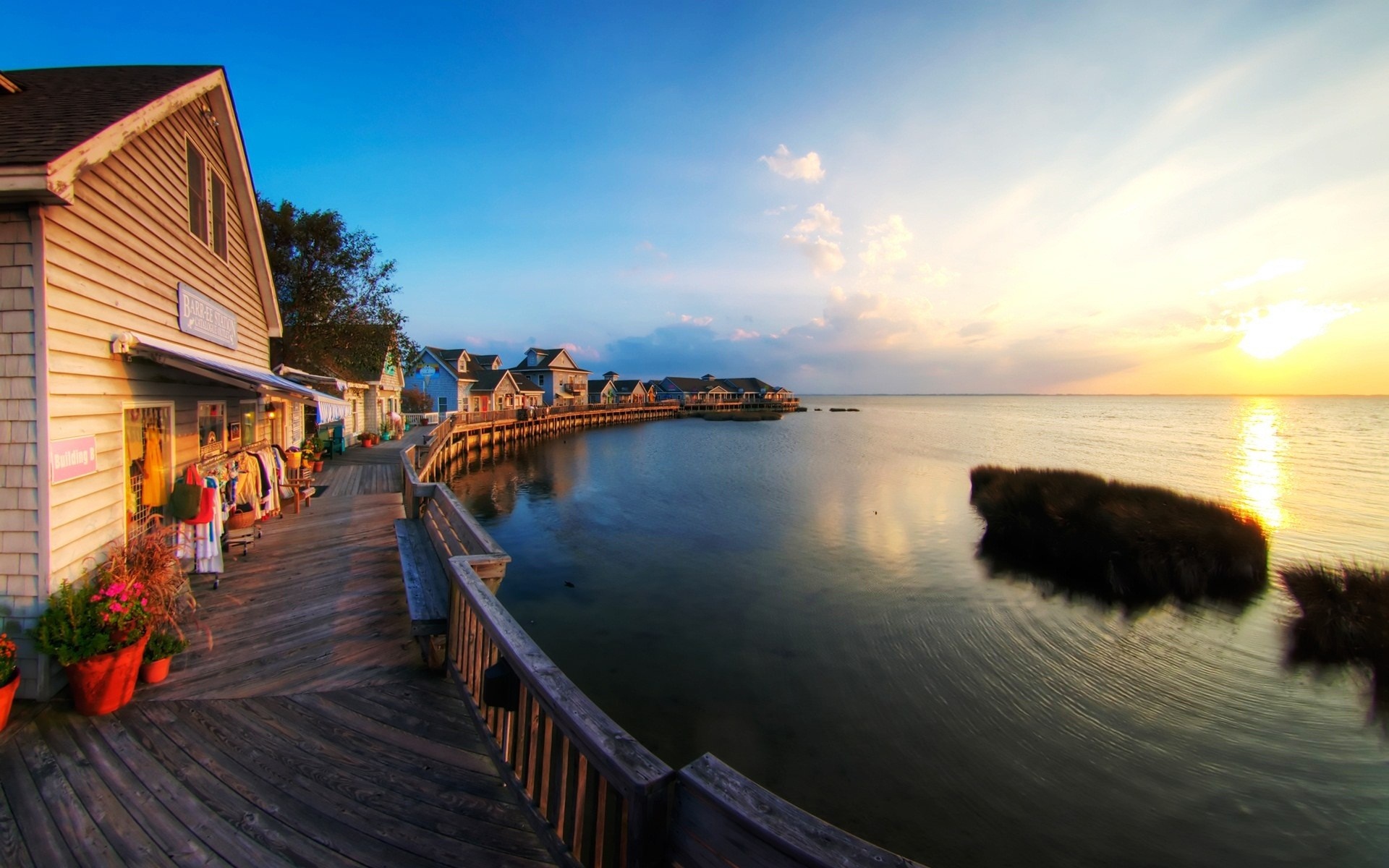 Boardwalk shops and houses by the water at sunset HD Wallpaper