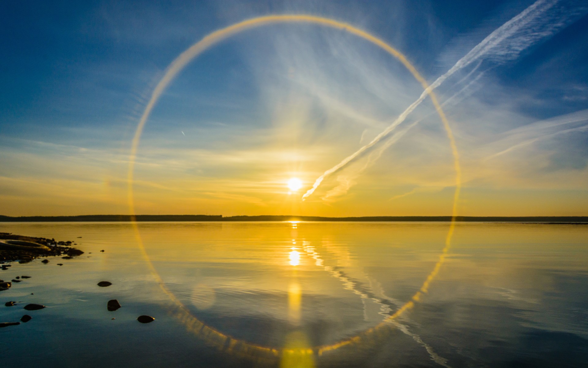 Sun halo over a calm lake at sunset HD Wallpaper