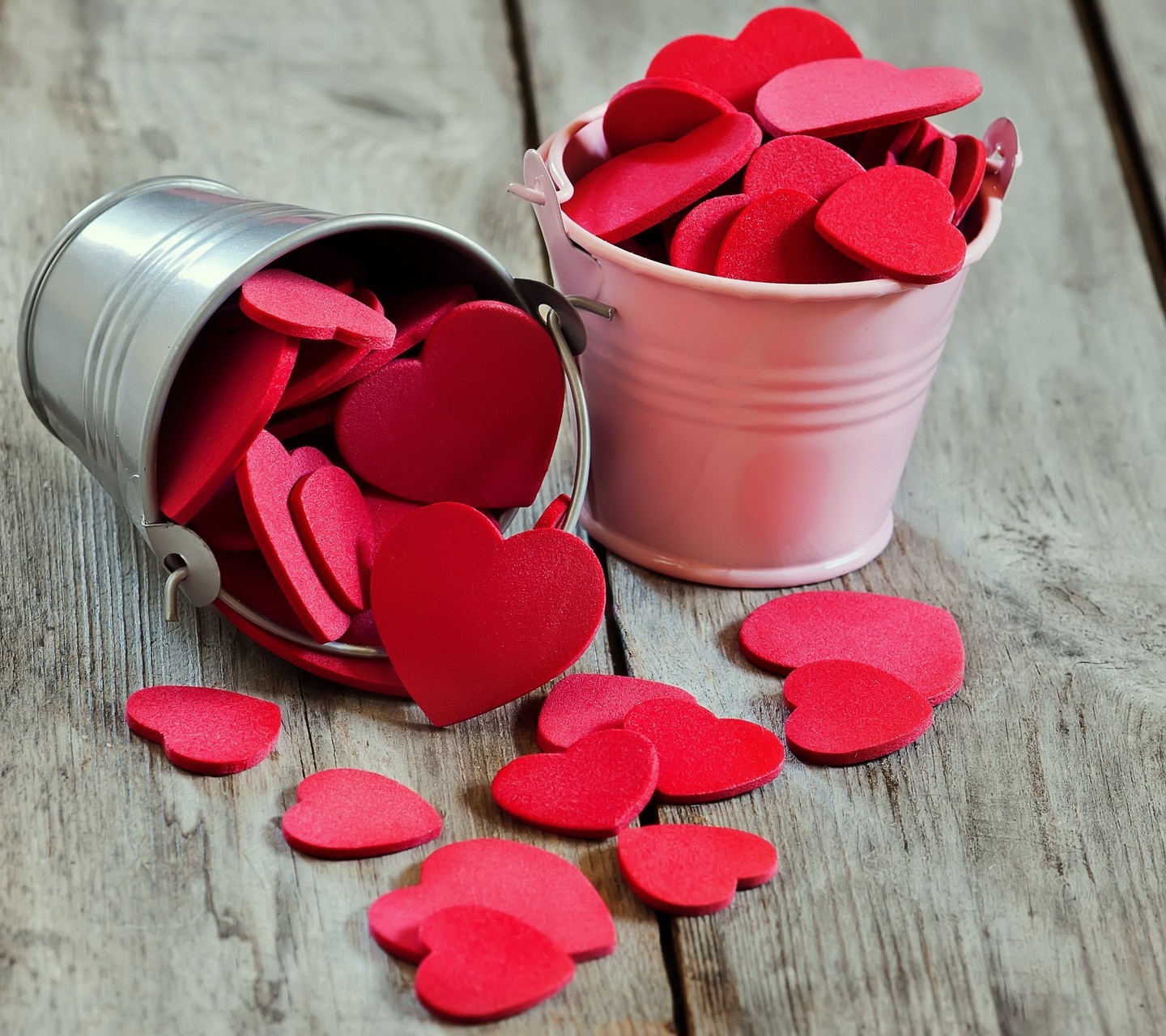 Buckets of red and pink hearts on wooden surface HD Wallpaper