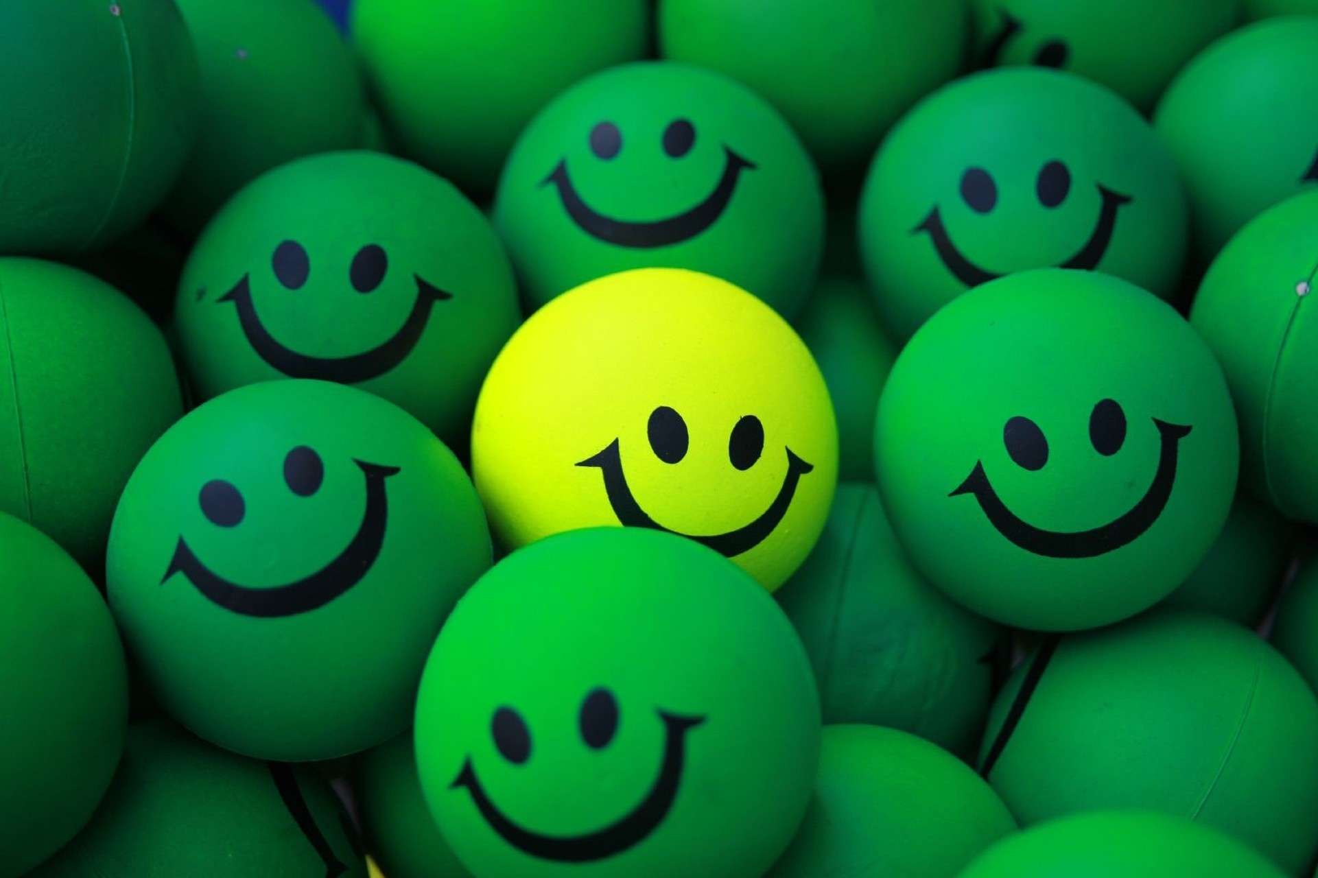 Yellow smiley face ball among green smiley face balls HD Wallpaper