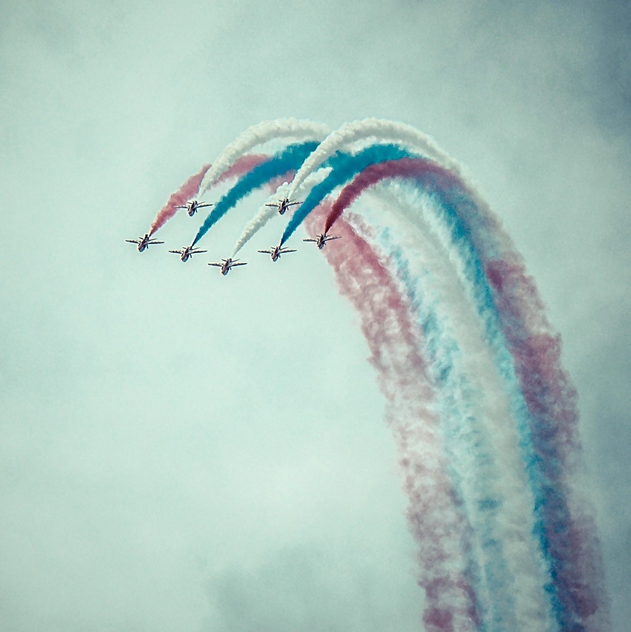 Airplanes performing aerobatics with red, white, and blue smoke HD Wallpaper
