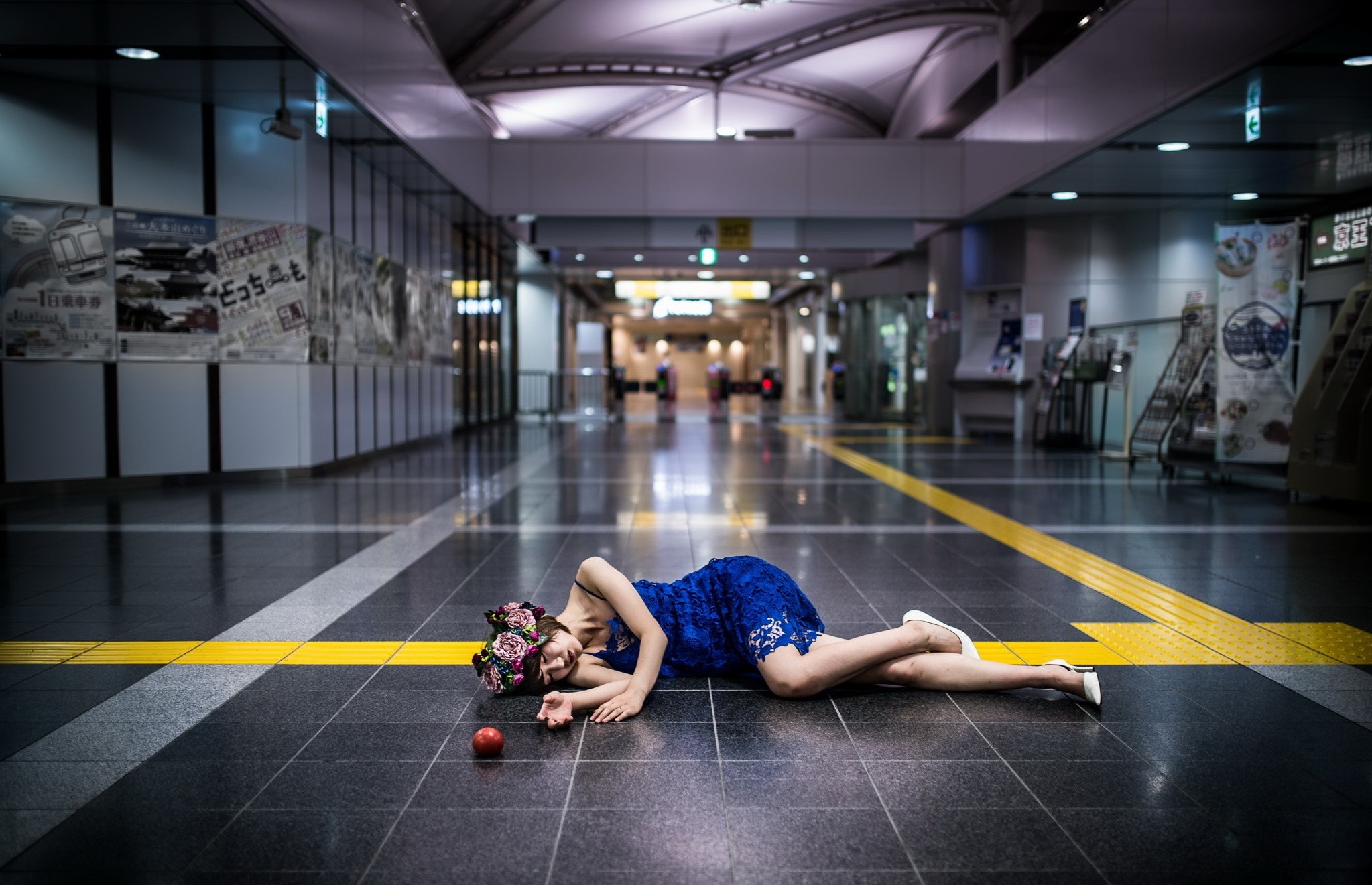 Woman in blue dress lying on train station floor HD Wallpaper