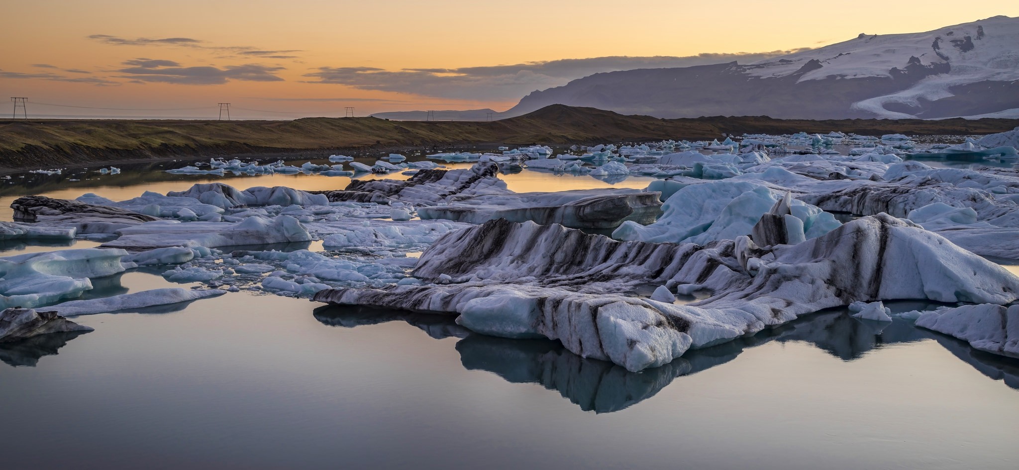 Icebergs floating in a glacial lake at sunset HD Wallpaper