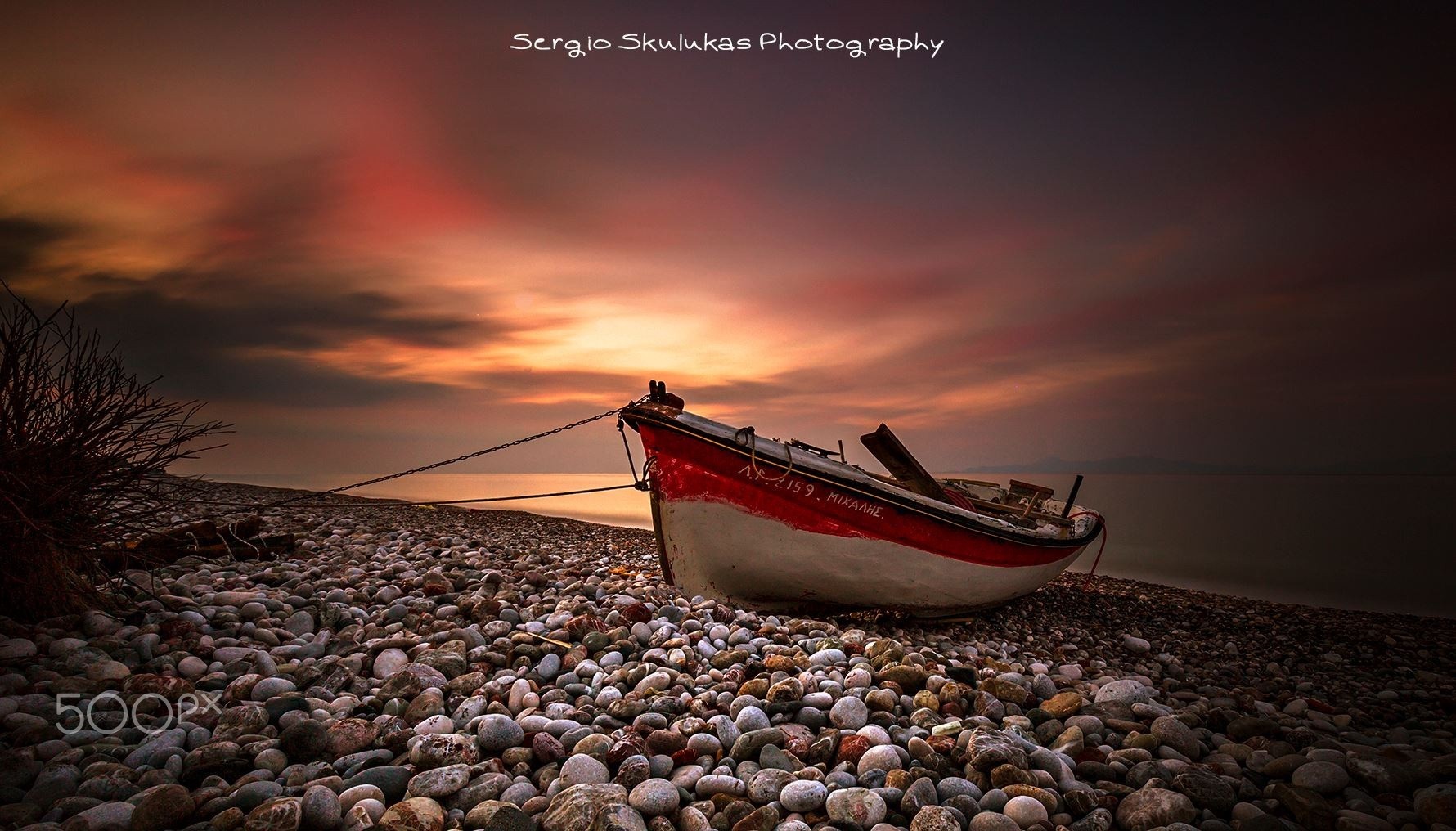 Boat on a pebble beach at sunset HD Wallpaper