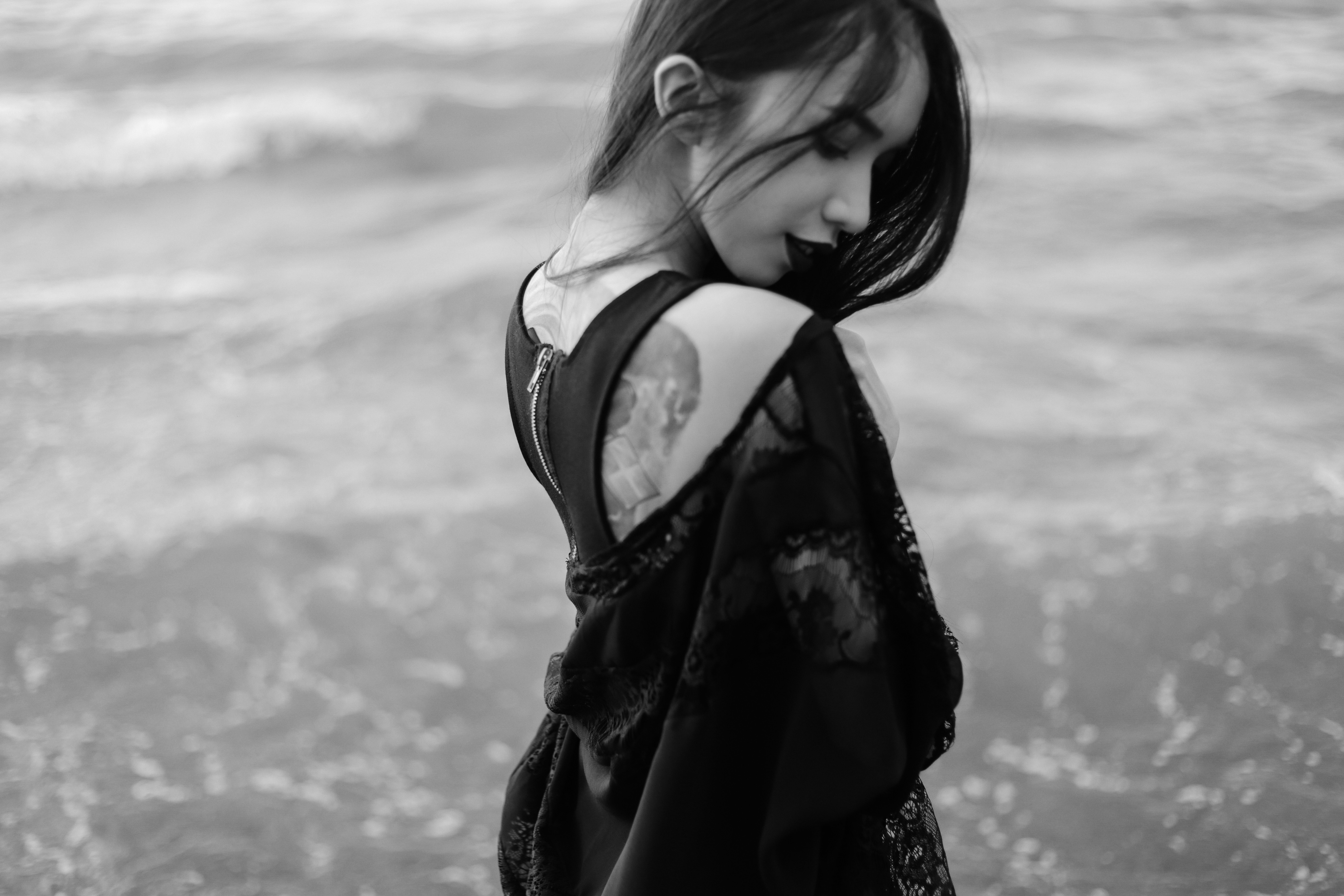 Monochrome portrait of a woman with a tattoo by the sea HD Wallpaper