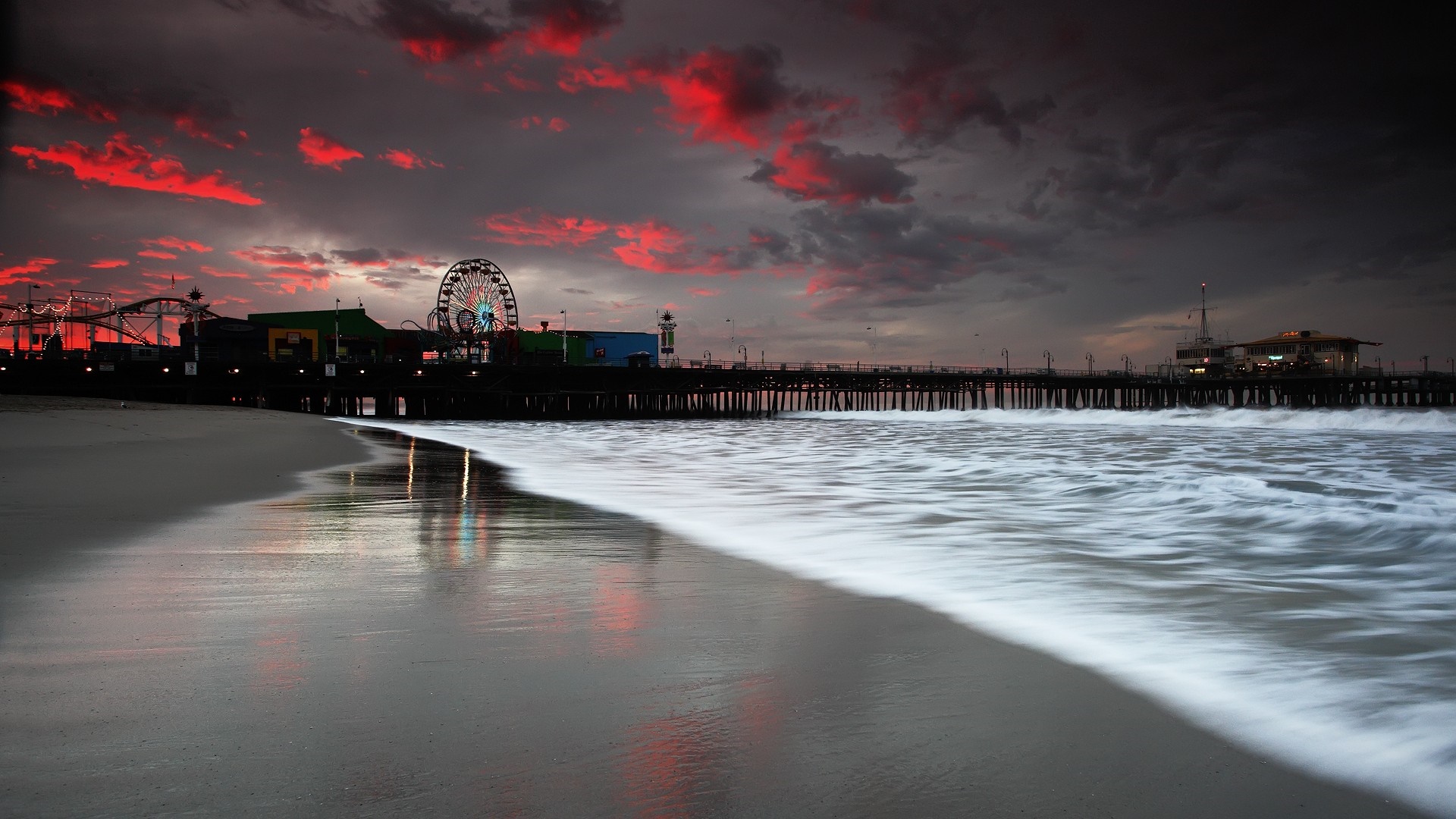 Santa Monica Pier at sunset with red clouds and ocean waves HD Wallpaper
