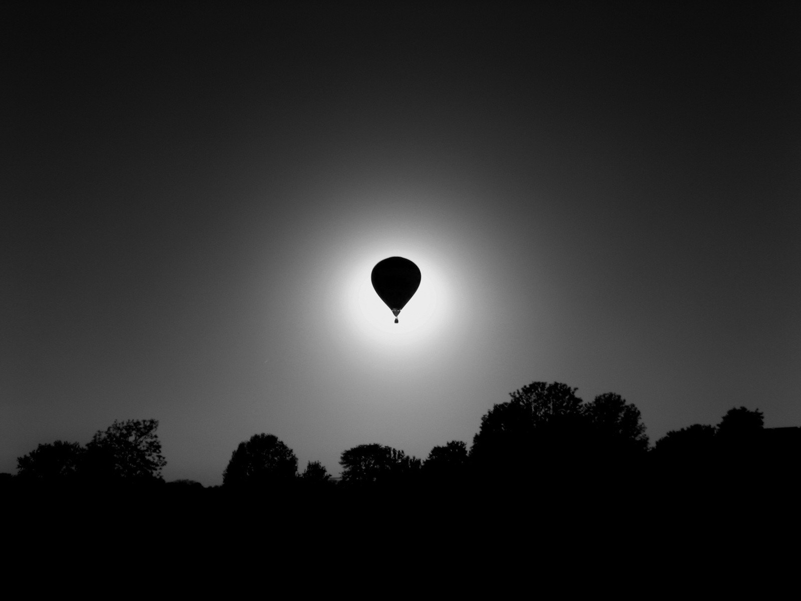 Hot air balloon silhouetted against the sun HD Wallpaper