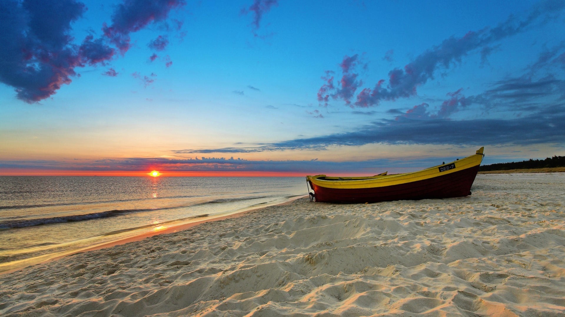 Boat on a sandy beach at sunset HD Wallpaper