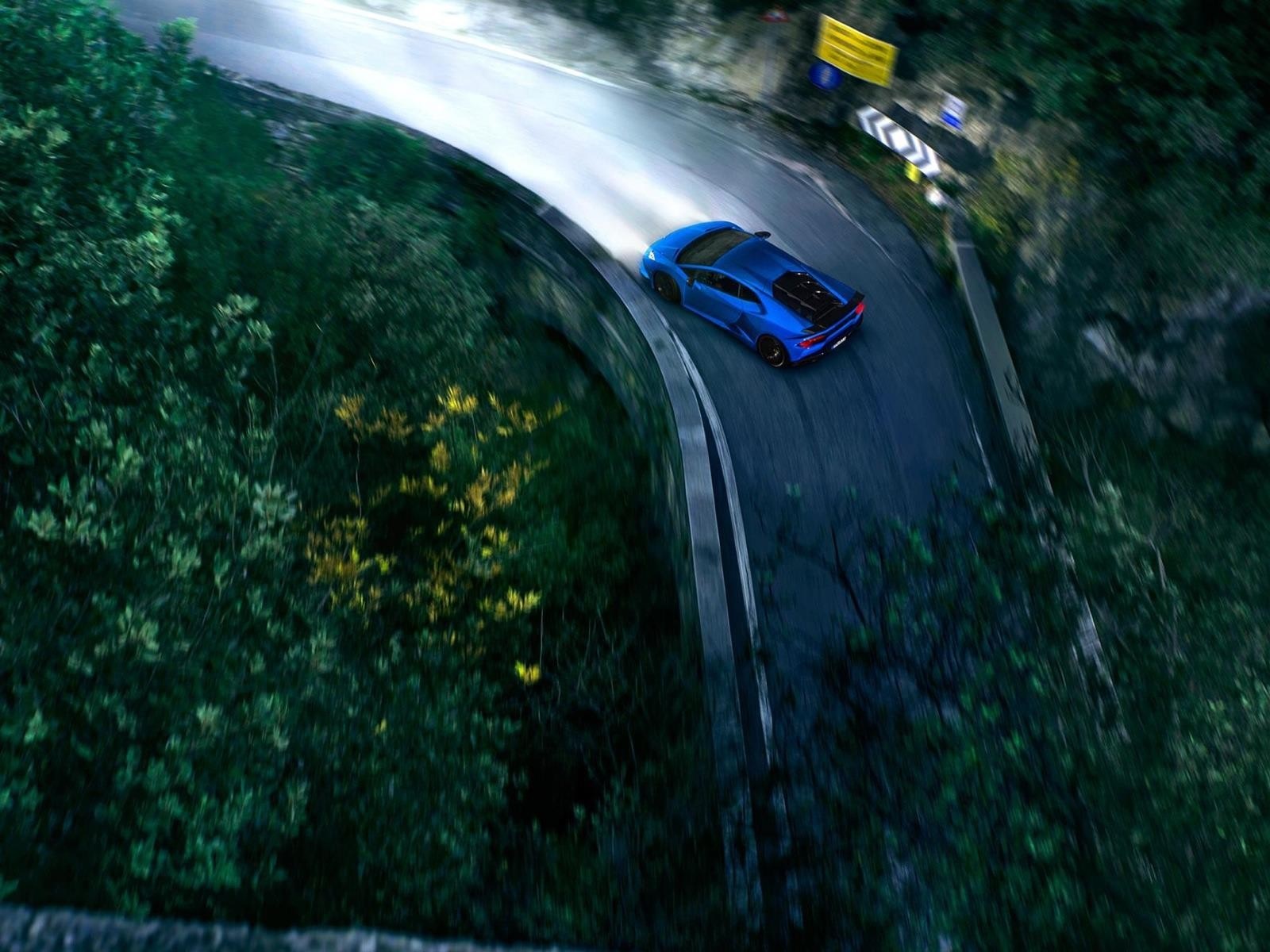 Blue Lamborghini Huracan driving on a winding road at night HD Wallpaper