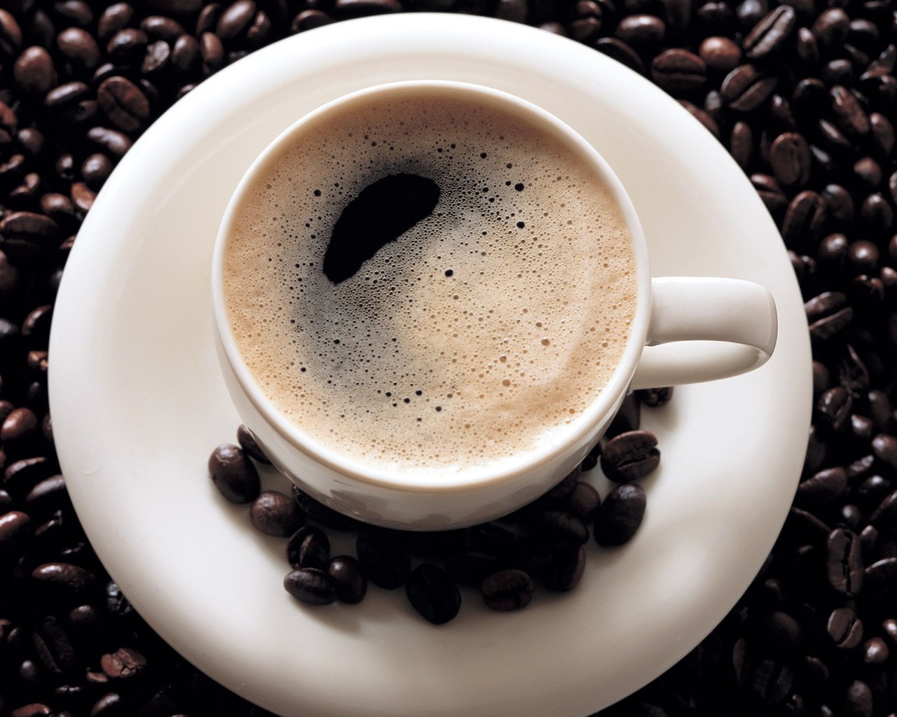 Cup of coffee on a saucer with coffee beans HD Wallpaper