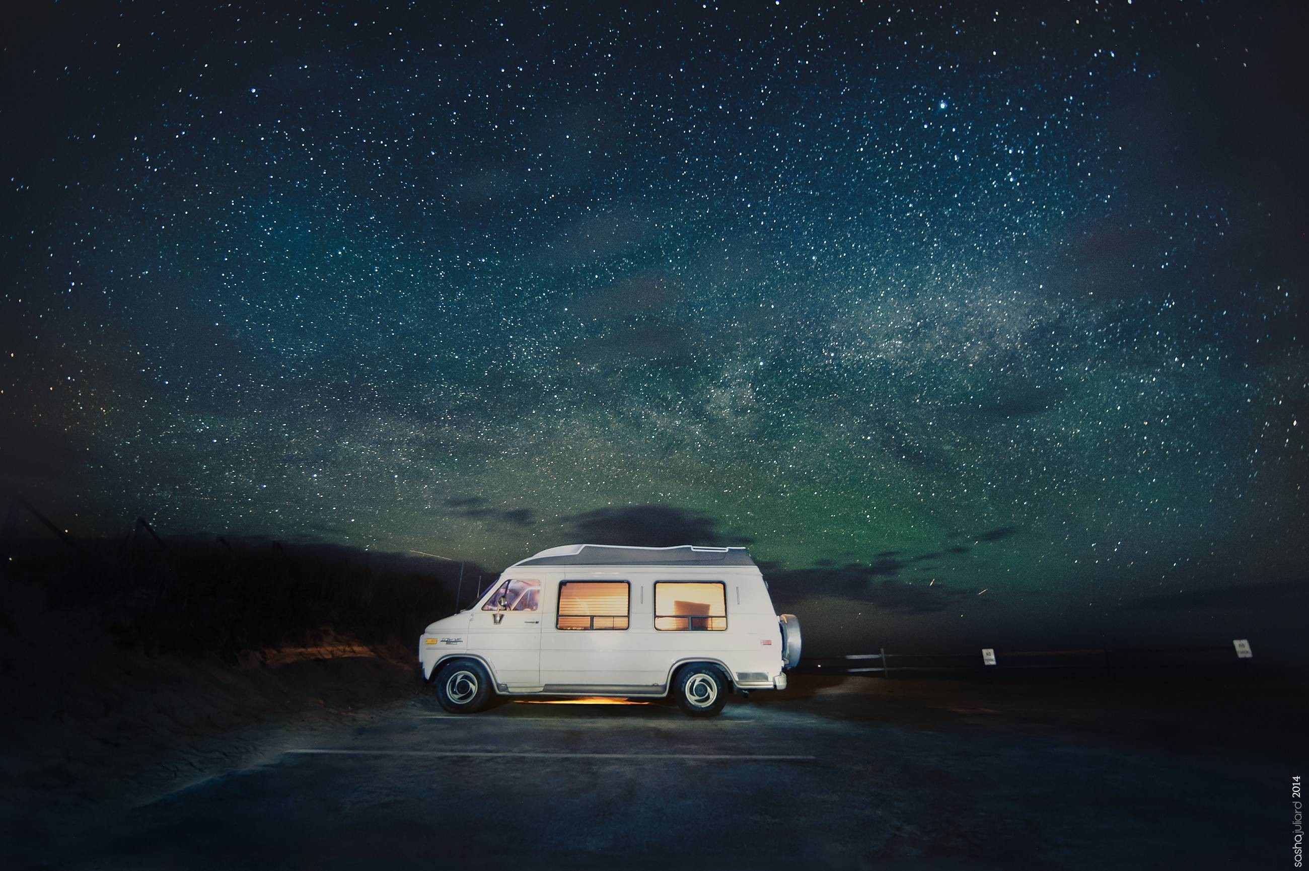 White camper van parked under a starry night sky HD Wallpaper