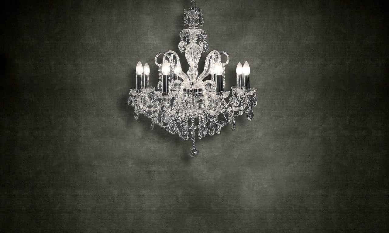 Crystal chandelier with candle-shaped lights on a dark textured wall HD Wallpaper