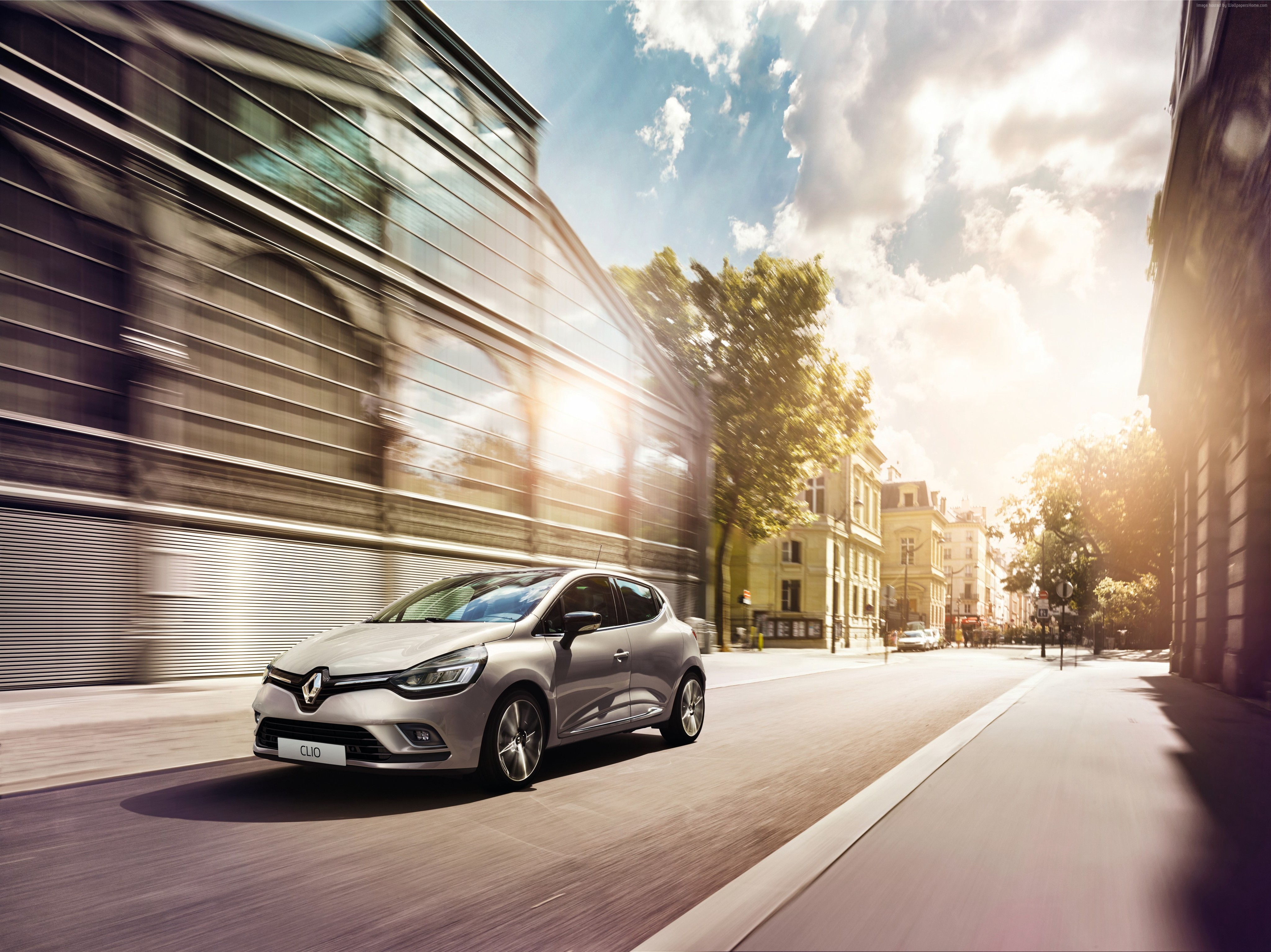 Silver Renault Clio driving on a city street HD Wallpaper