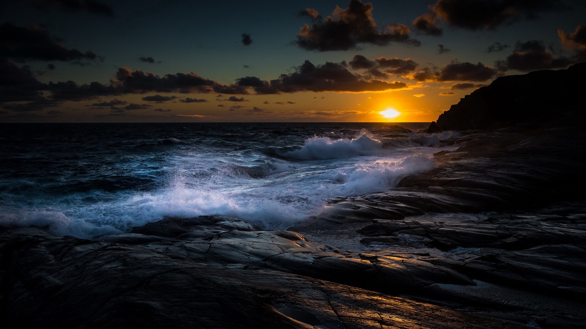 Sunset over stormy ocean waves crashing on rocky shore HD Wallpaper