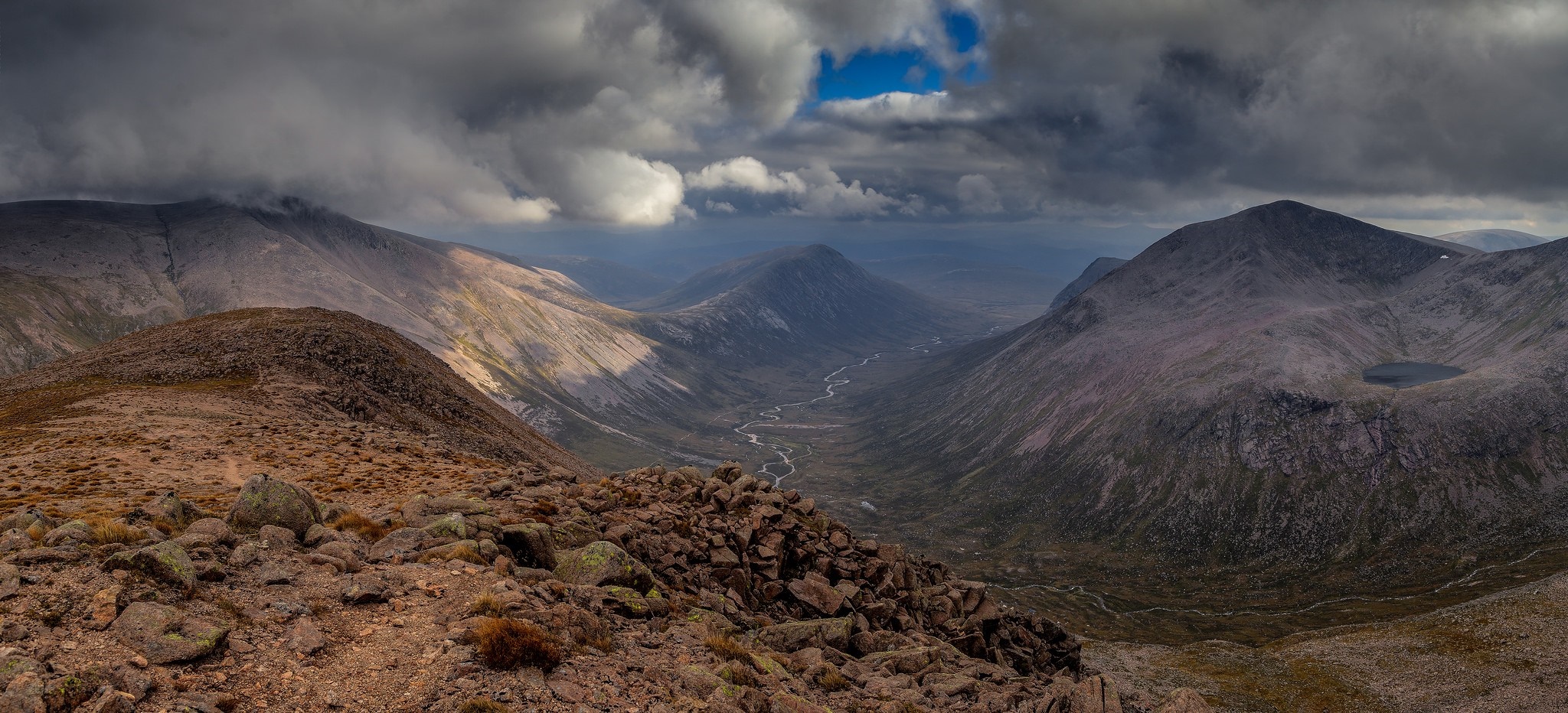 Panoramic view of a mountain valley with dramatic clouds HD Wallpaper