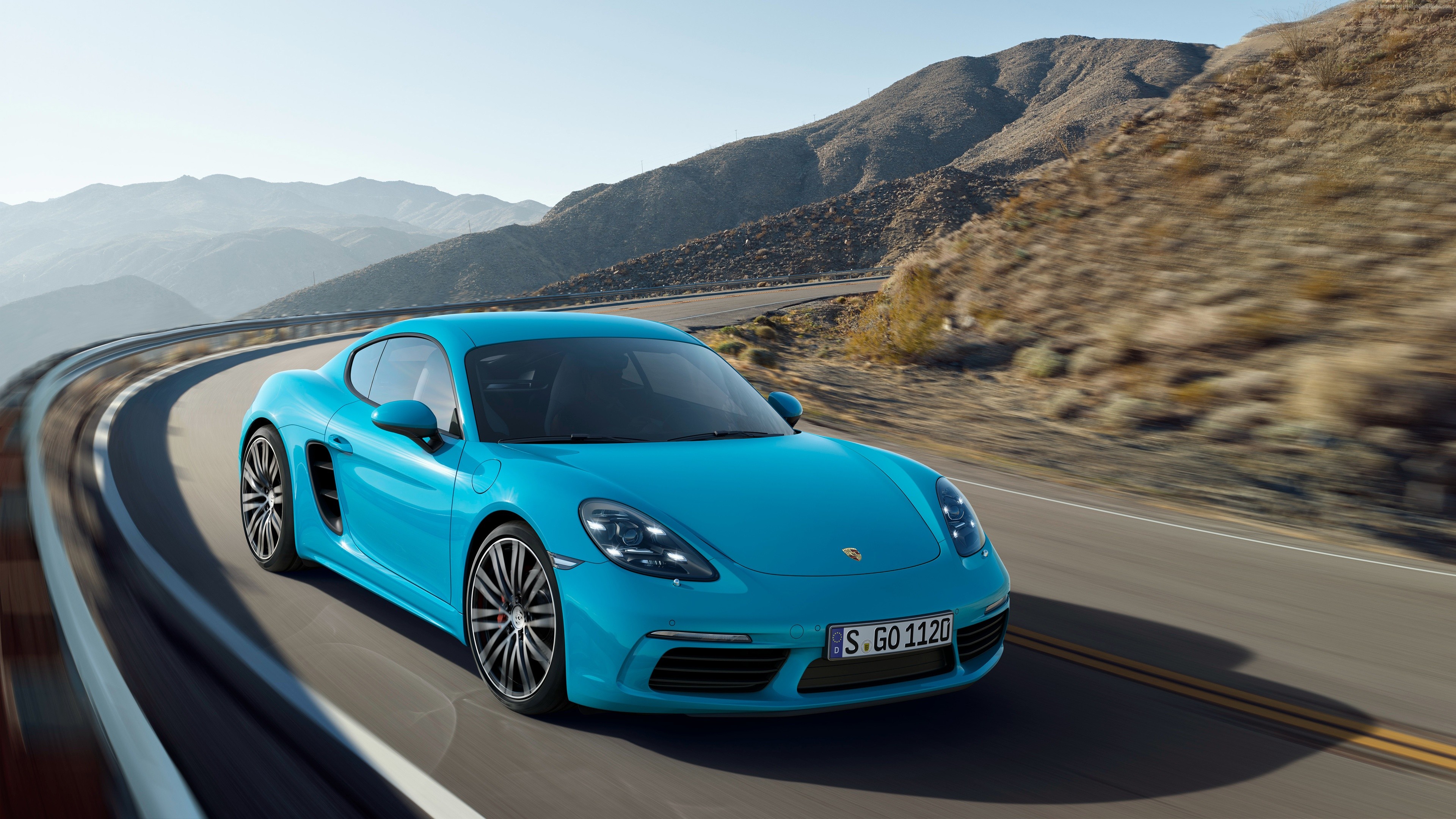 Blue Porsche 718 Cayman S driving on a mountain road HD Wallpaper