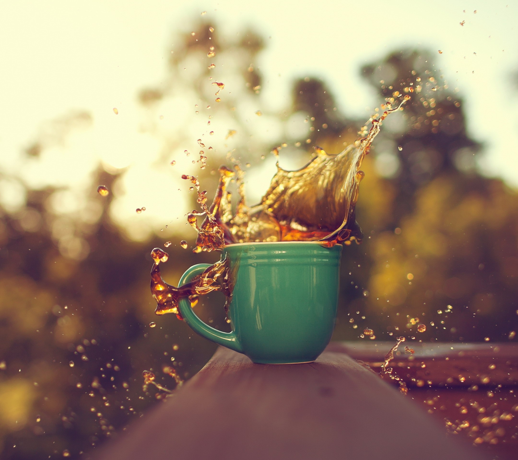 Coffee splash from a green mug outdoors HD Wallpaper