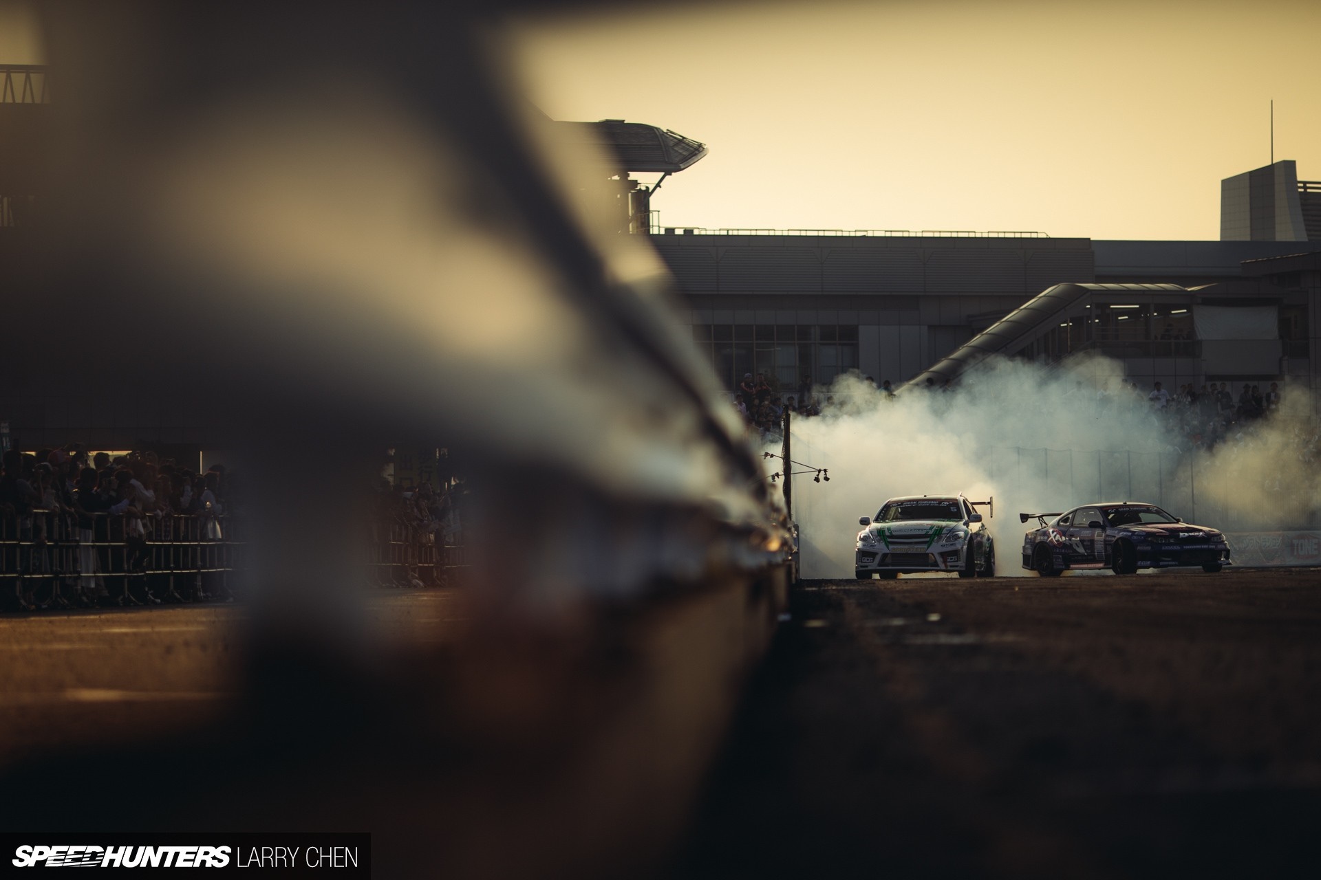 Drifting cars creating smoke at sunset HD Wallpaper