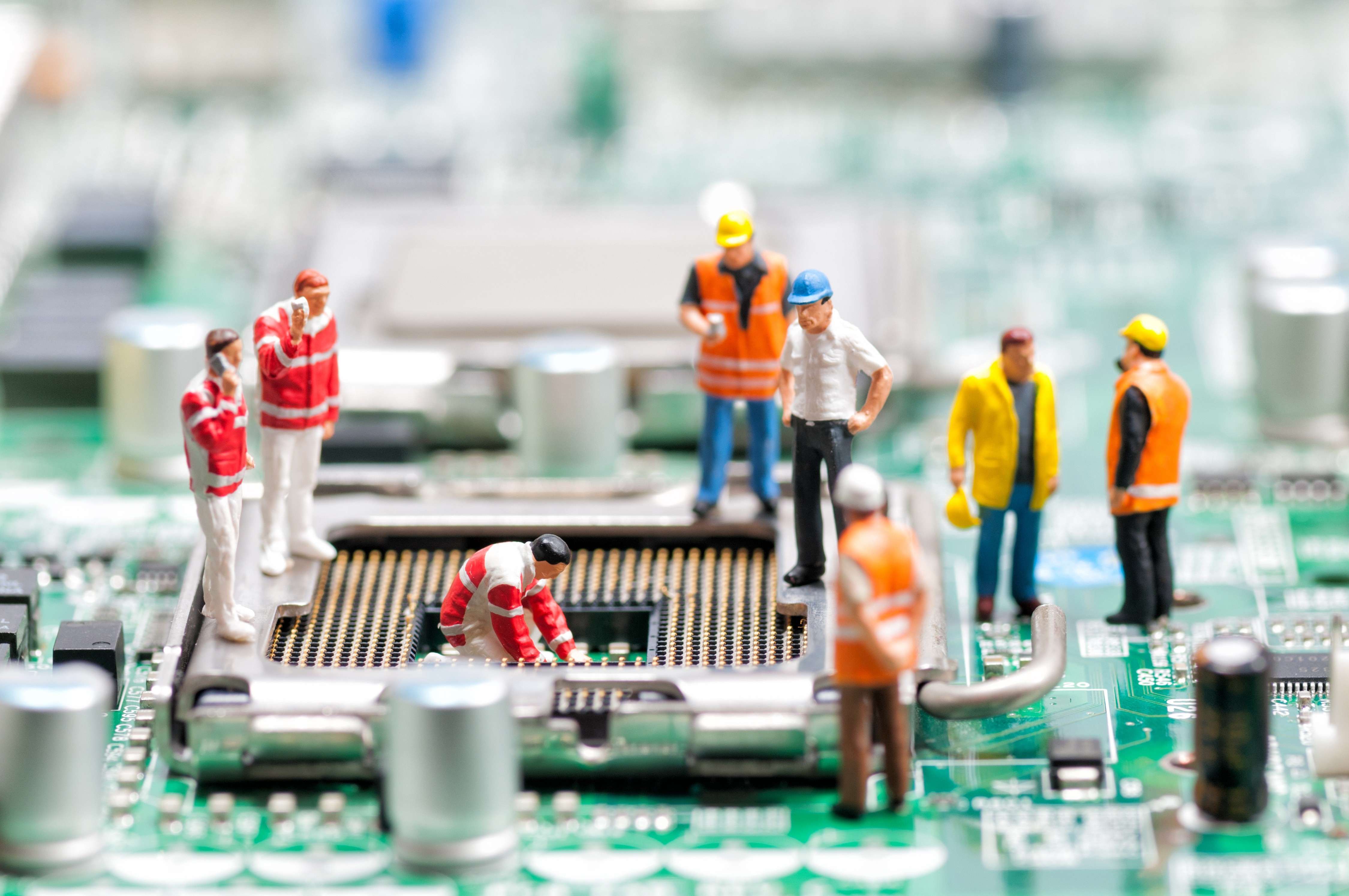 Miniature construction workers on a computer motherboard HD Wallpaper