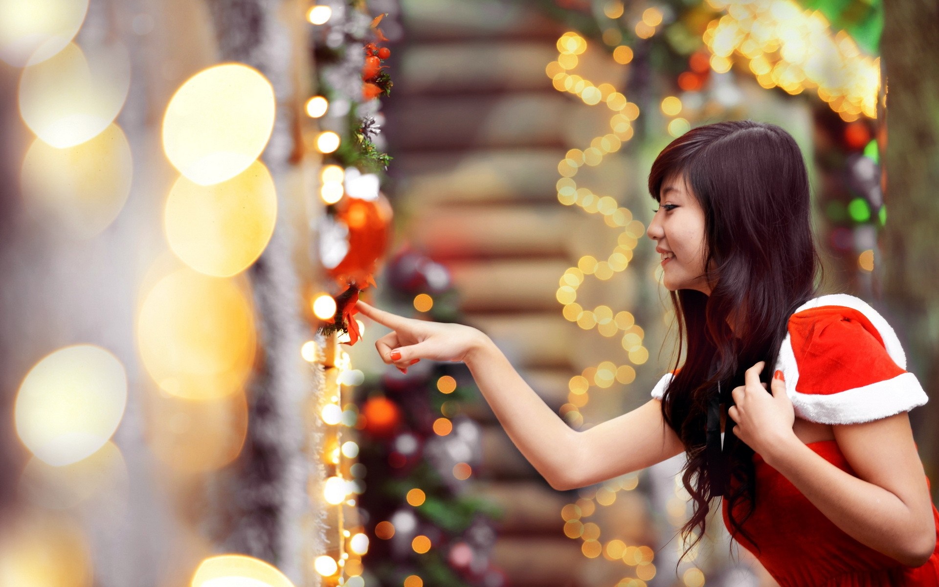 Woman in Santa costume touching Christmas lights HD Wallpaper