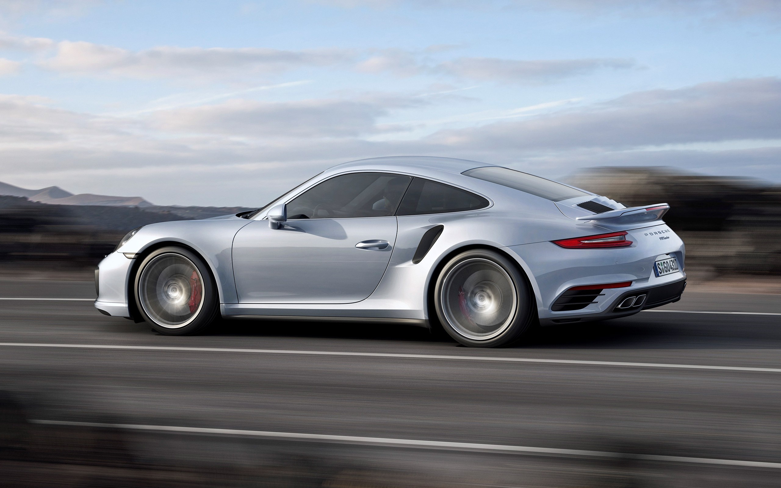 Silver Porsche 911 Turbo S driving on a road HD Wallpaper