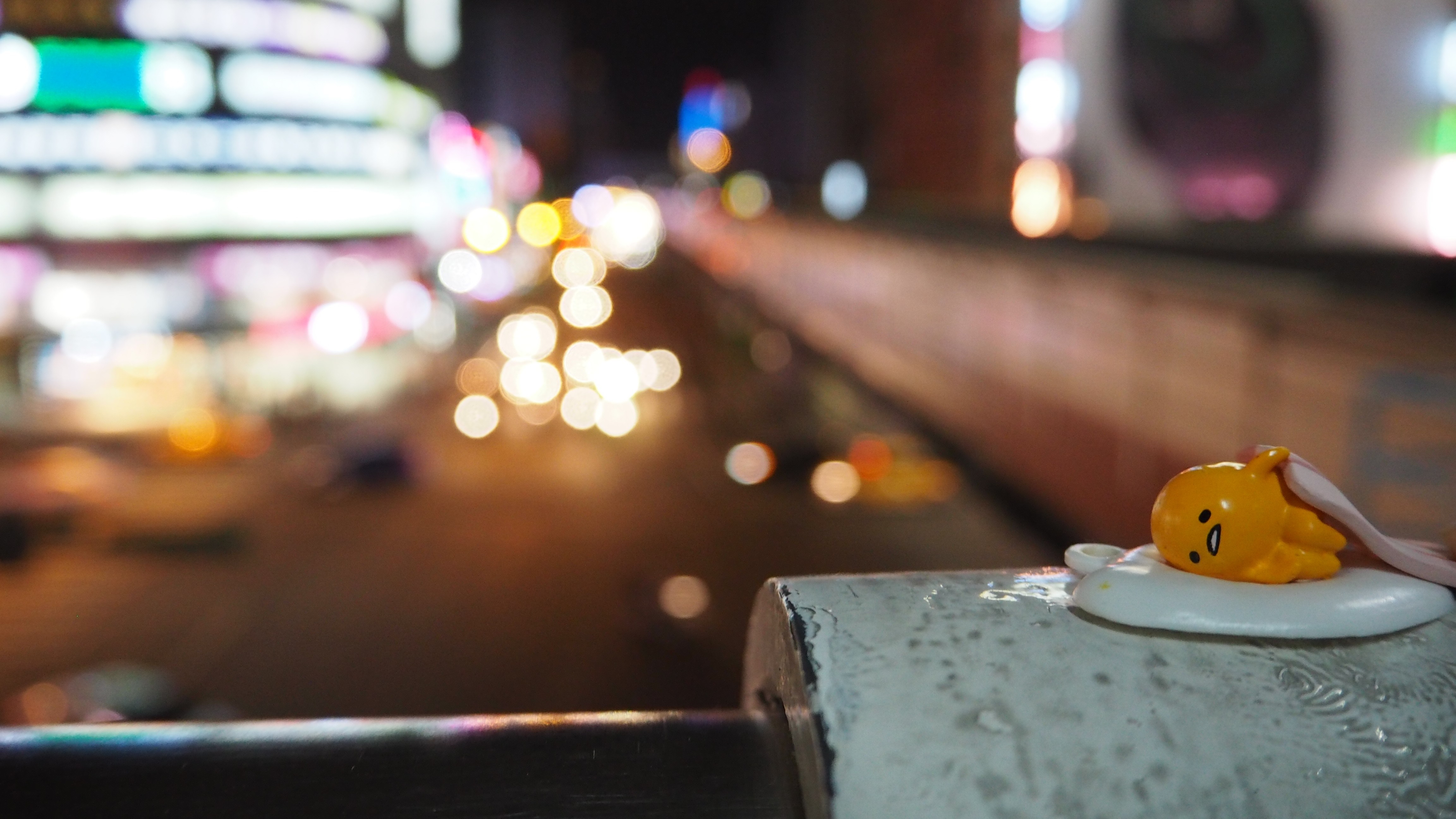 Gudetama figurine on a railing at night in Taiwan HD Wallpaper