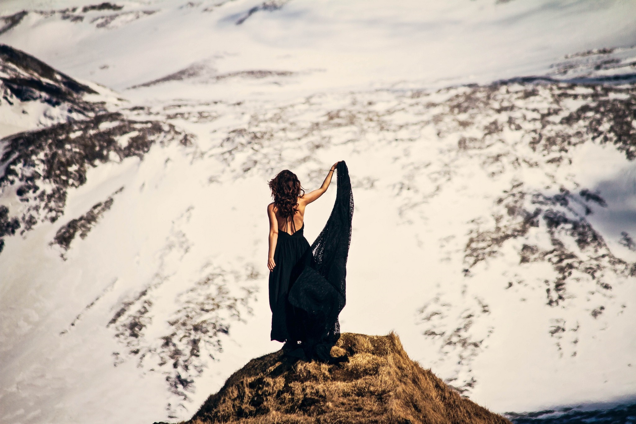 Woman in black dress on snowy mountain peak HD Wallpaper