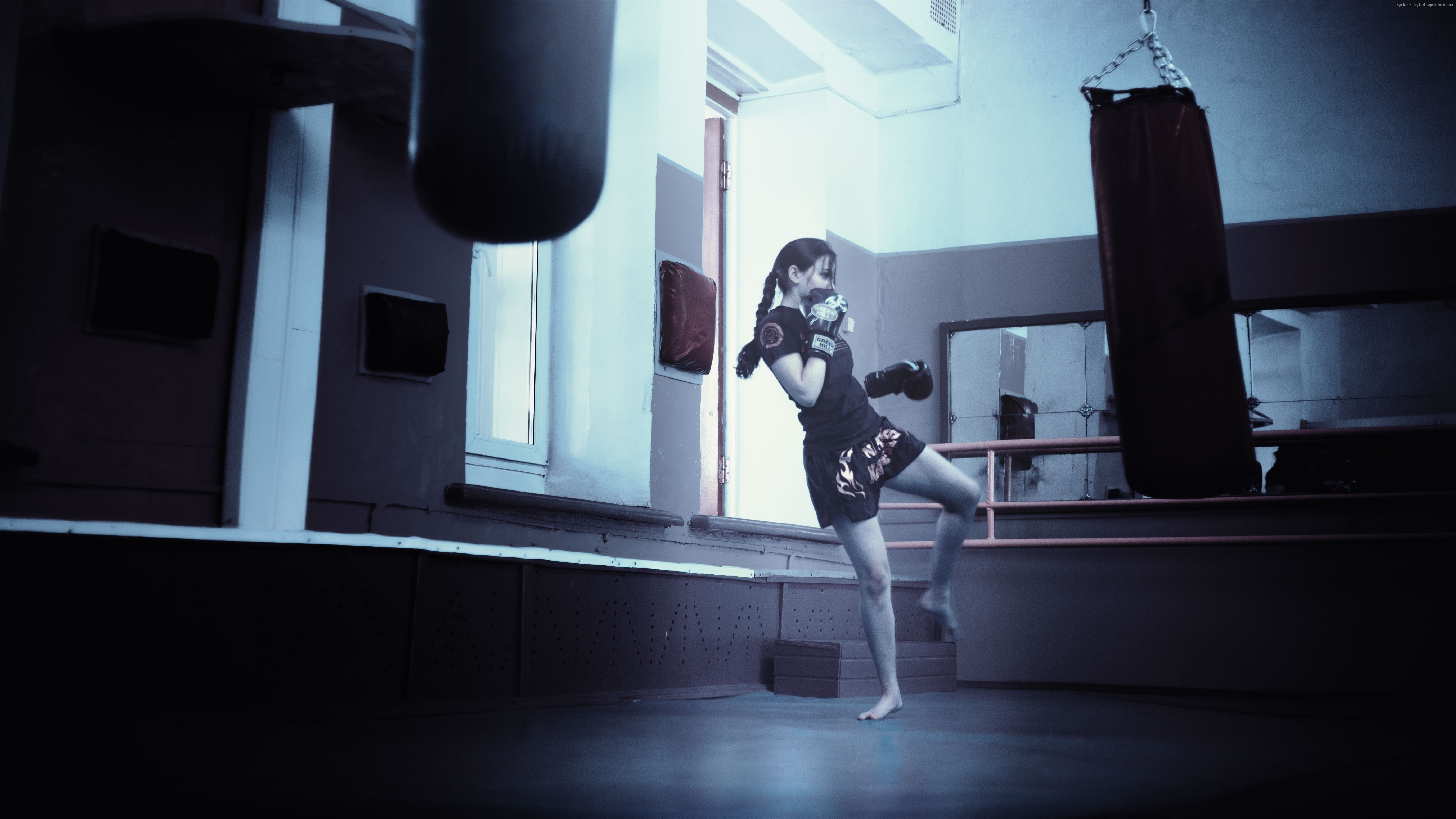 Girl training in a boxing gym with punching bags HD Wallpaper
