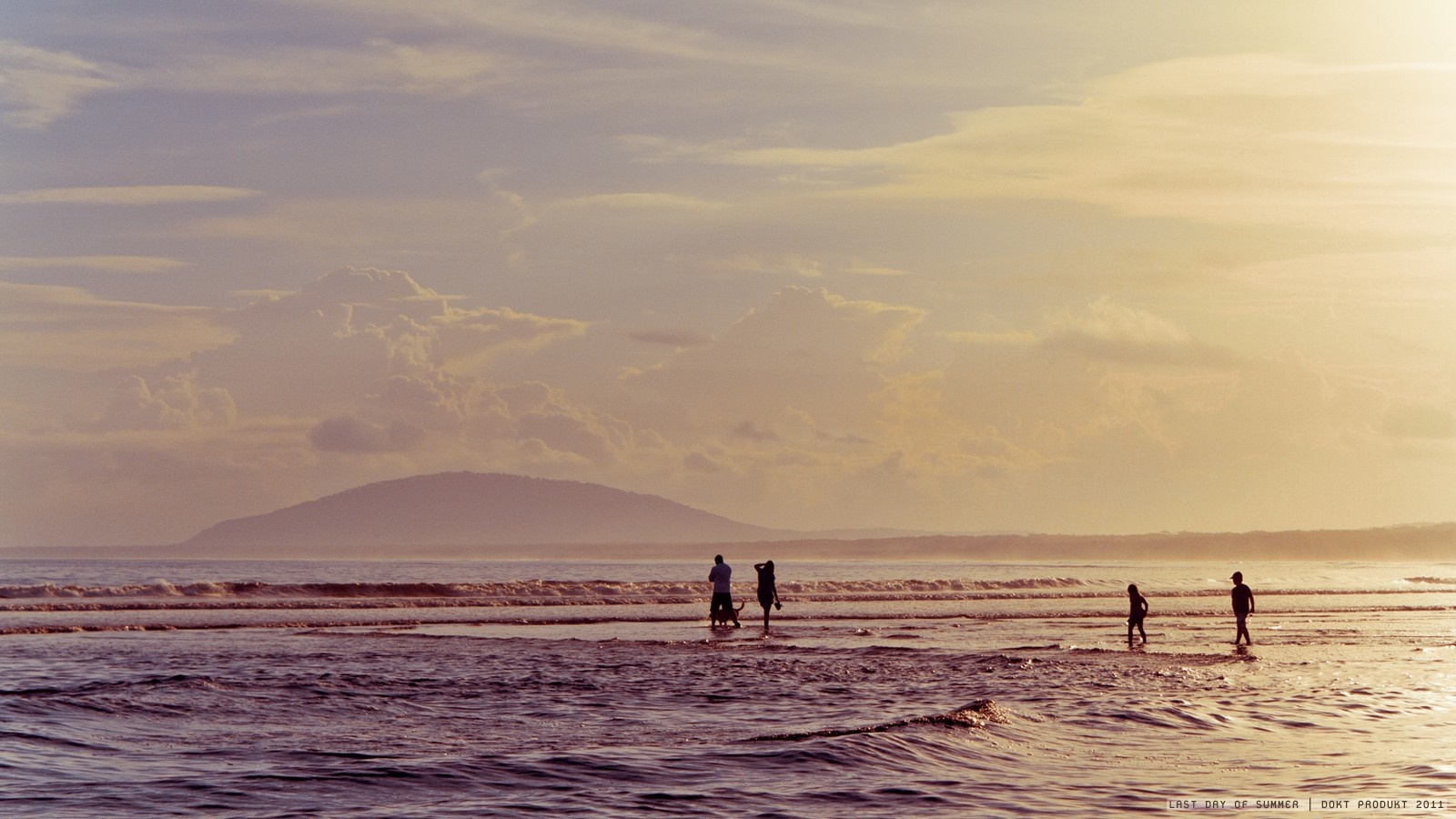 People walking on a beach at sunset HD Wallpaper