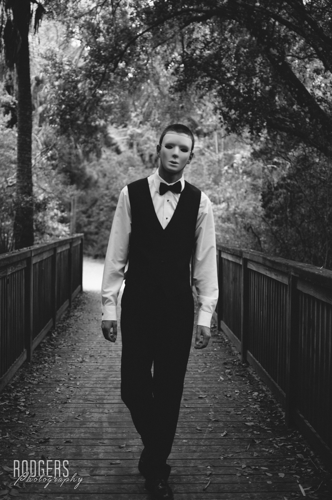 Man in mask and suit on a wooden bridge HD Wallpaper