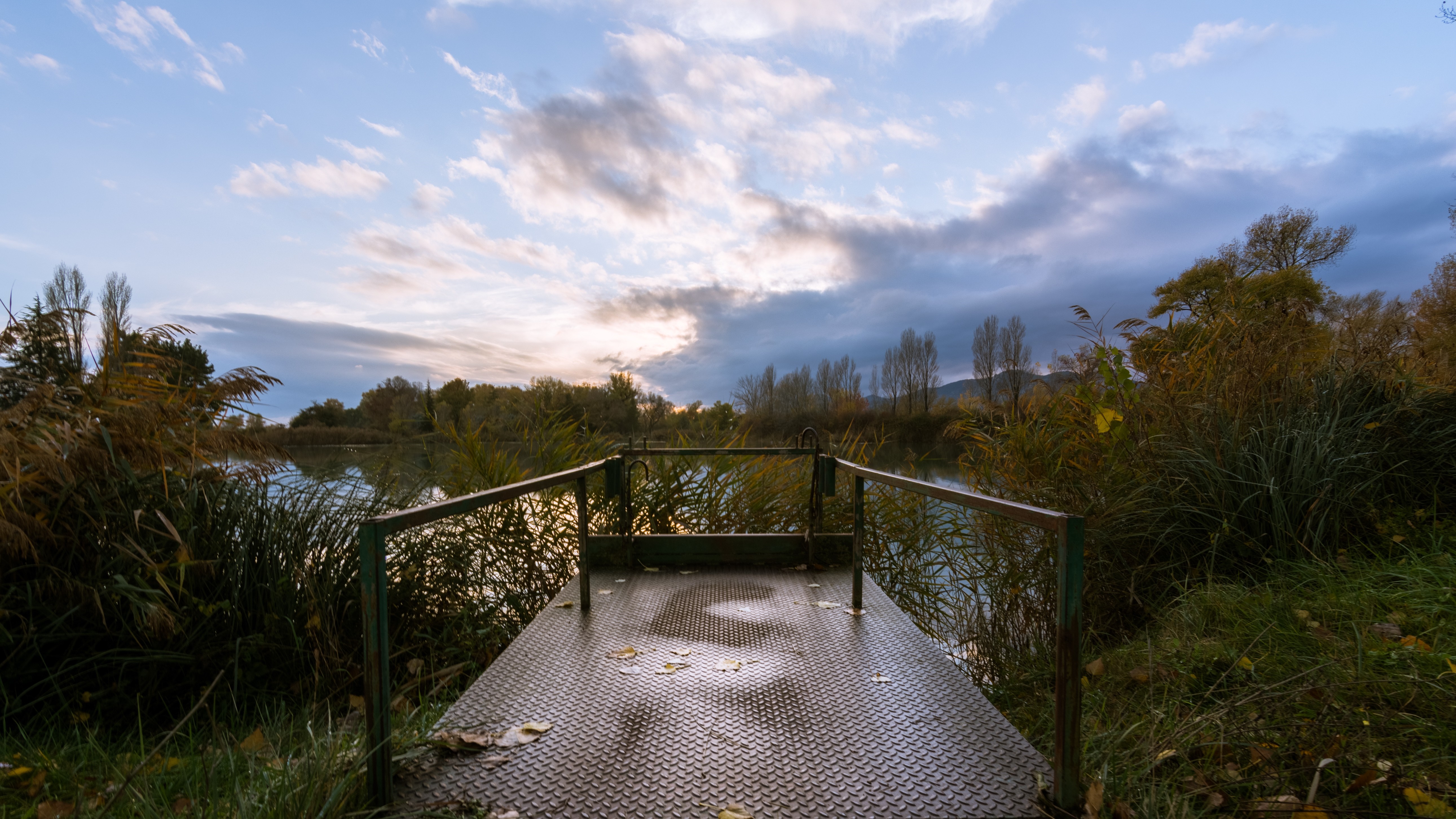 Metal platform on a lake with autumn foliage and clouds HD Wallpaper