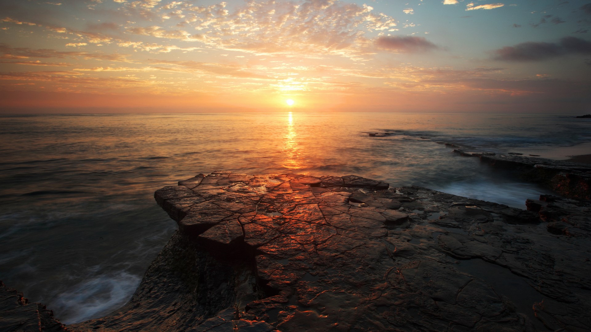 Sunset over the ocean with rocky shore HD Wallpaper