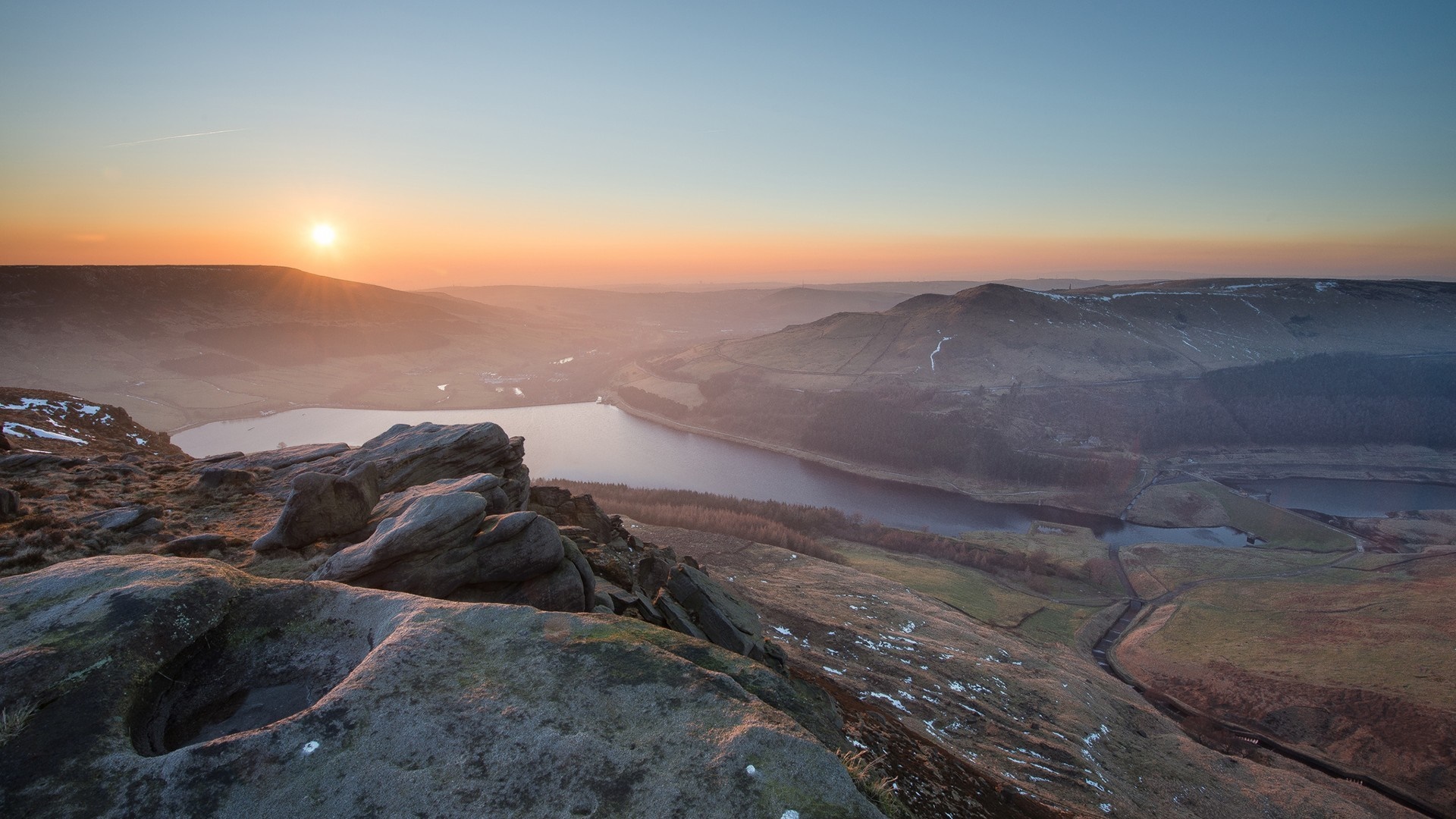 Sunrise over a mountain lake with rocky foreground HD Wallpaper