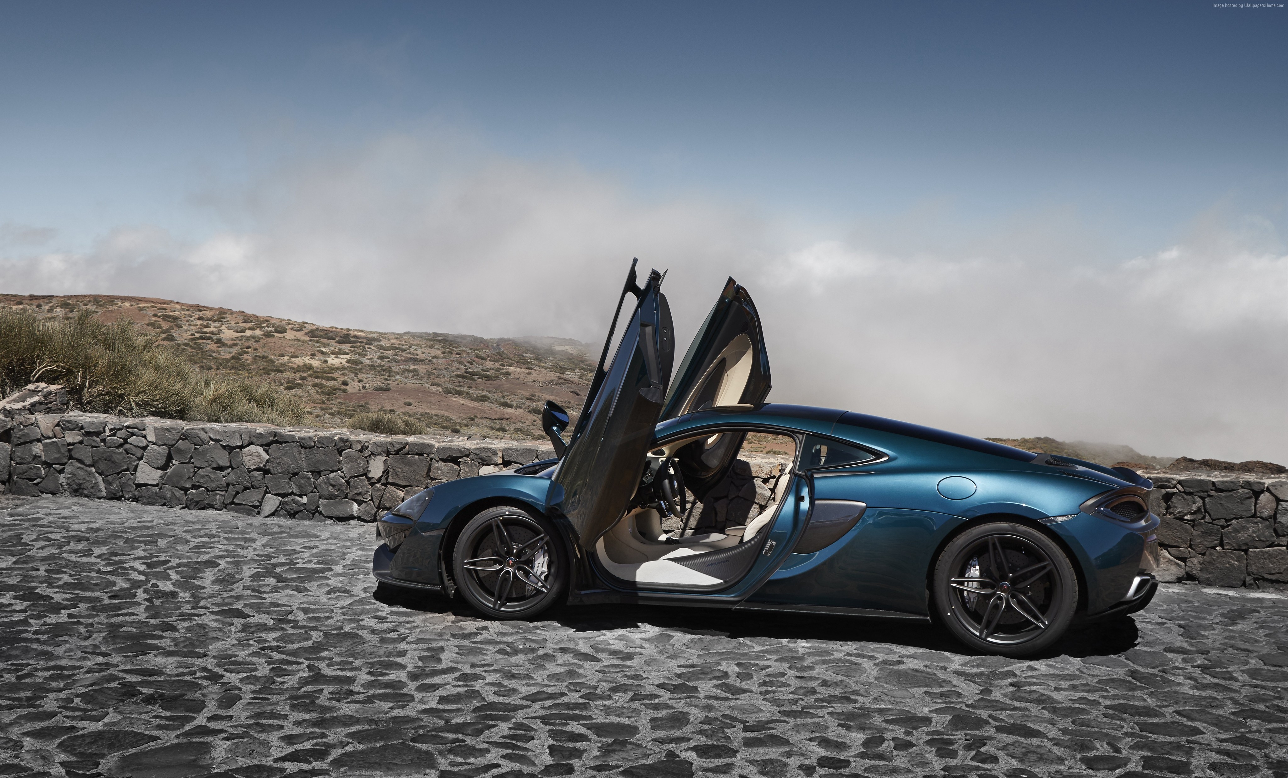 McLaren 570S supercar with doors open on a stone road HD Wallpaper