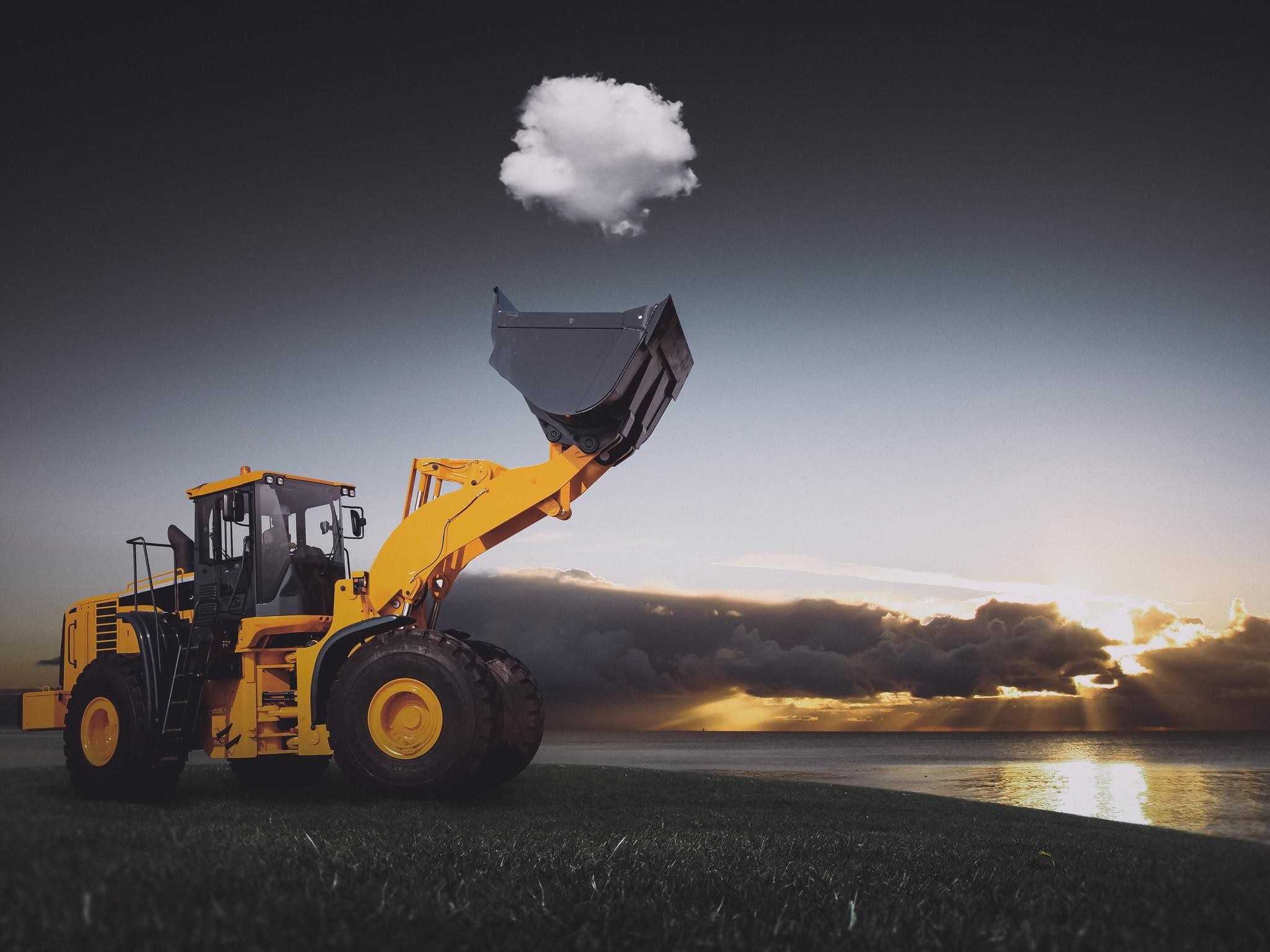 Yellow front loader lifting a cloud over the sea at sunset HD Wallpaper