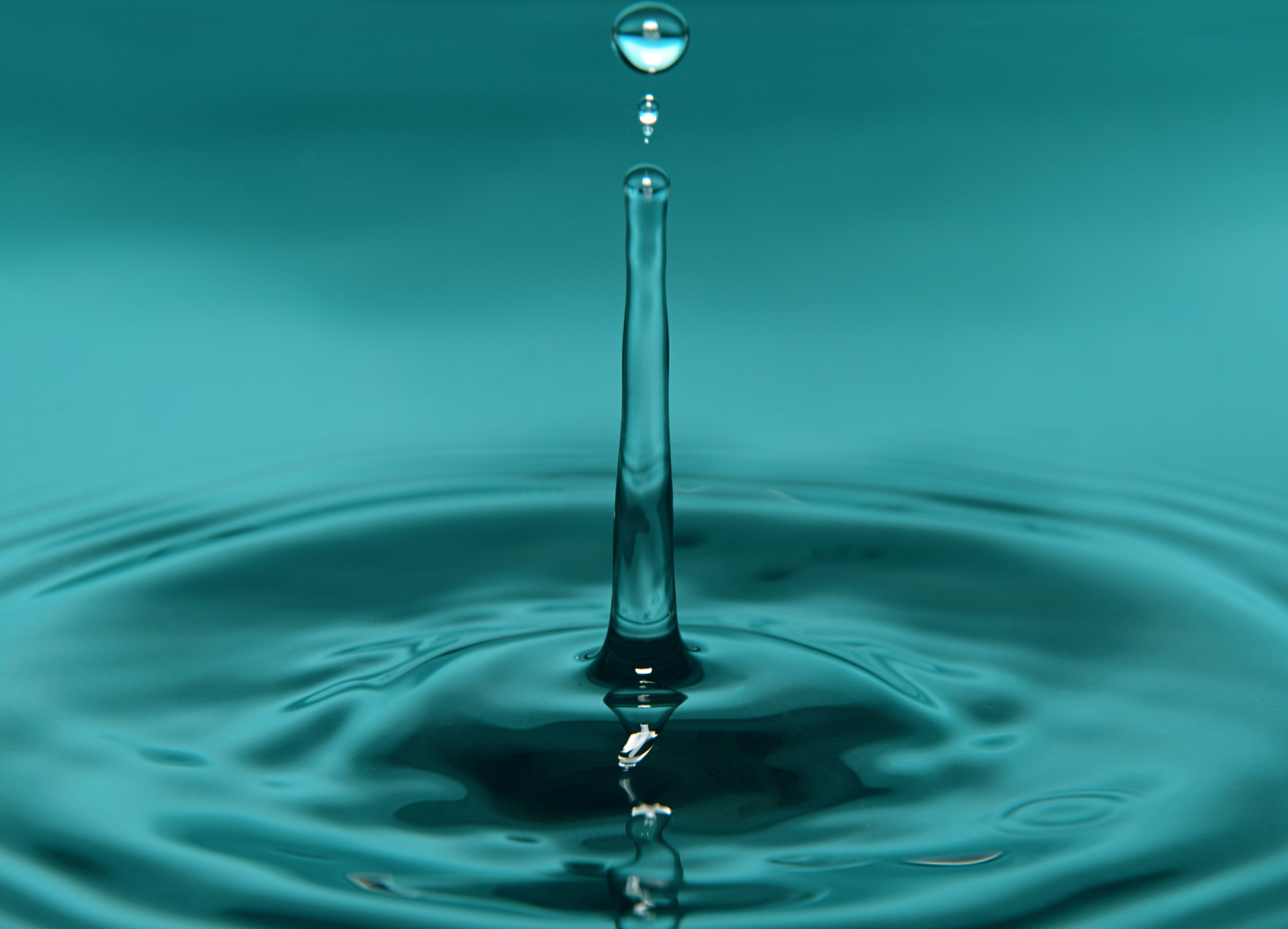 Water drop falling into blue water HD Wallpaper