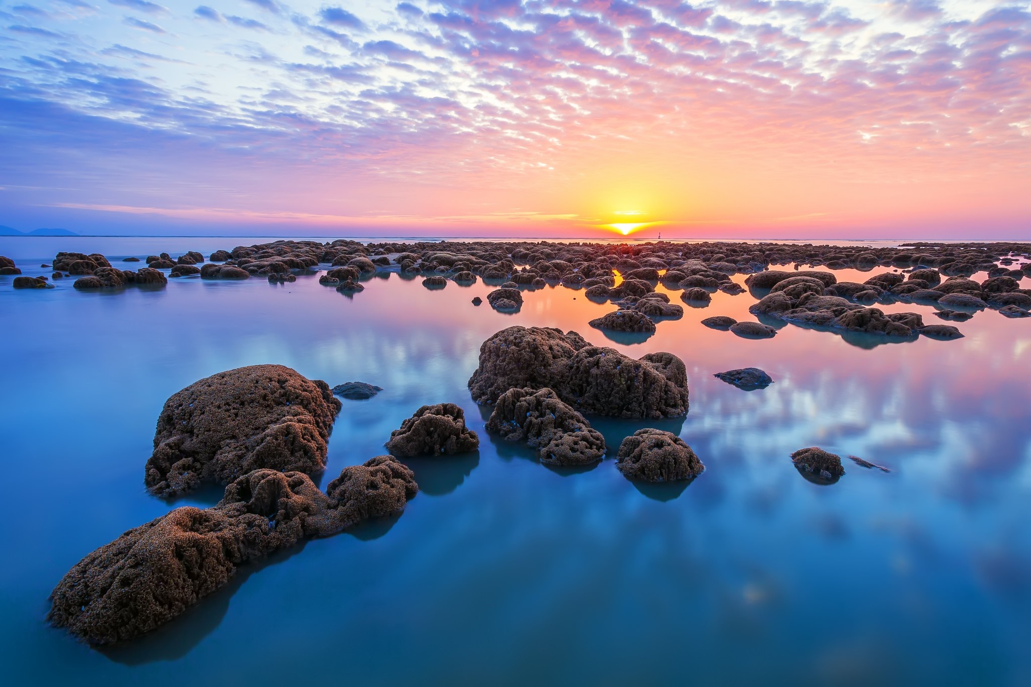 Sunset over the sea with rocks and reflection HD Wallpaper