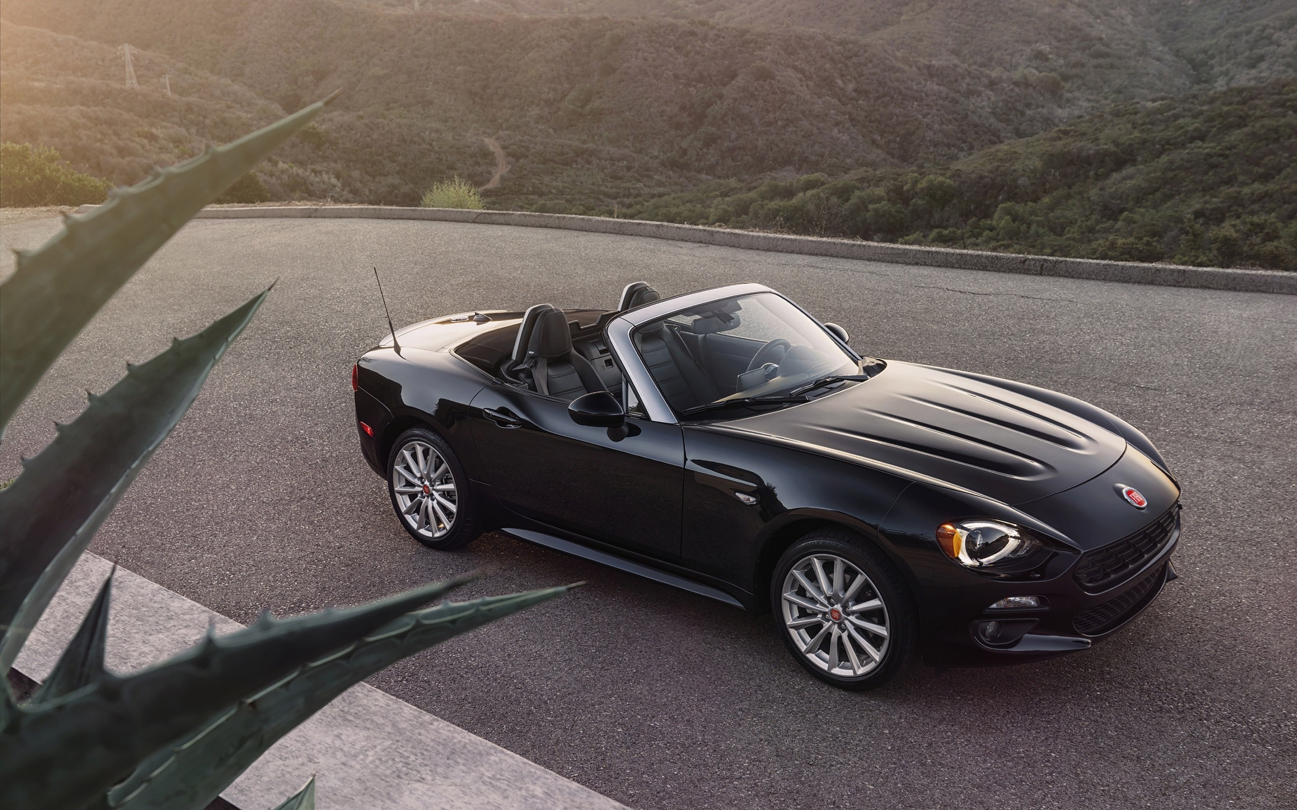 Black Fiat 124 Spider convertible parked on a mountain road HD Wallpaper