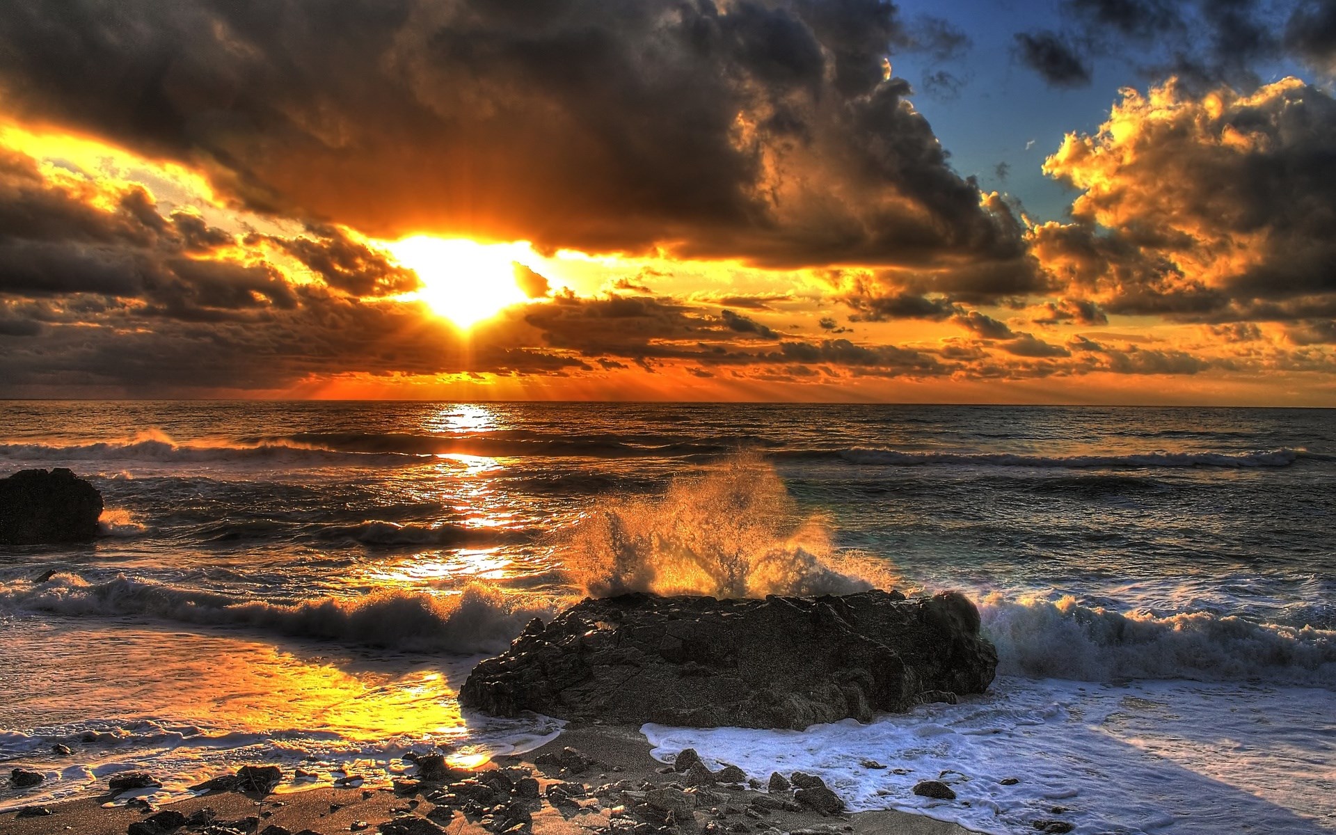 Sunset over the ocean with waves crashing on rocks HD Wallpaper