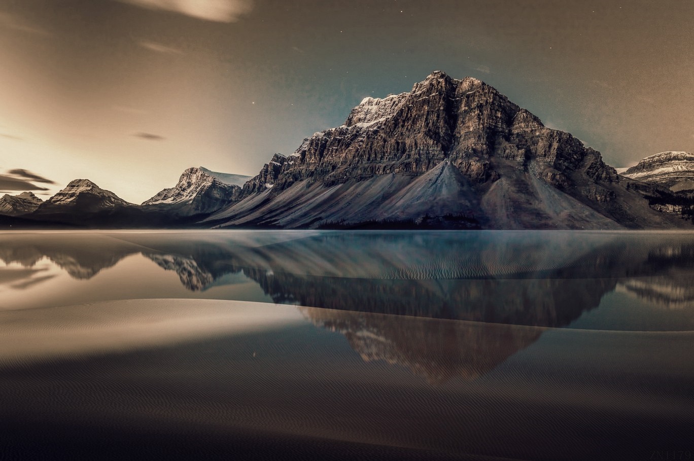 Snow-capped mountains reflected in a calm lake at dawn HD Wallpaper