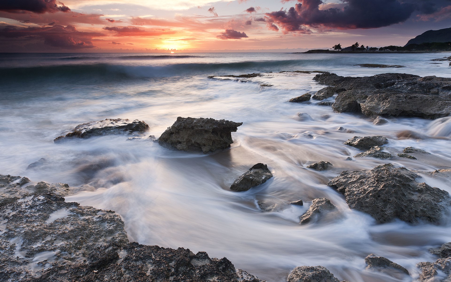 Ocean waves crashing on rocky shore at sunset HD Wallpaper