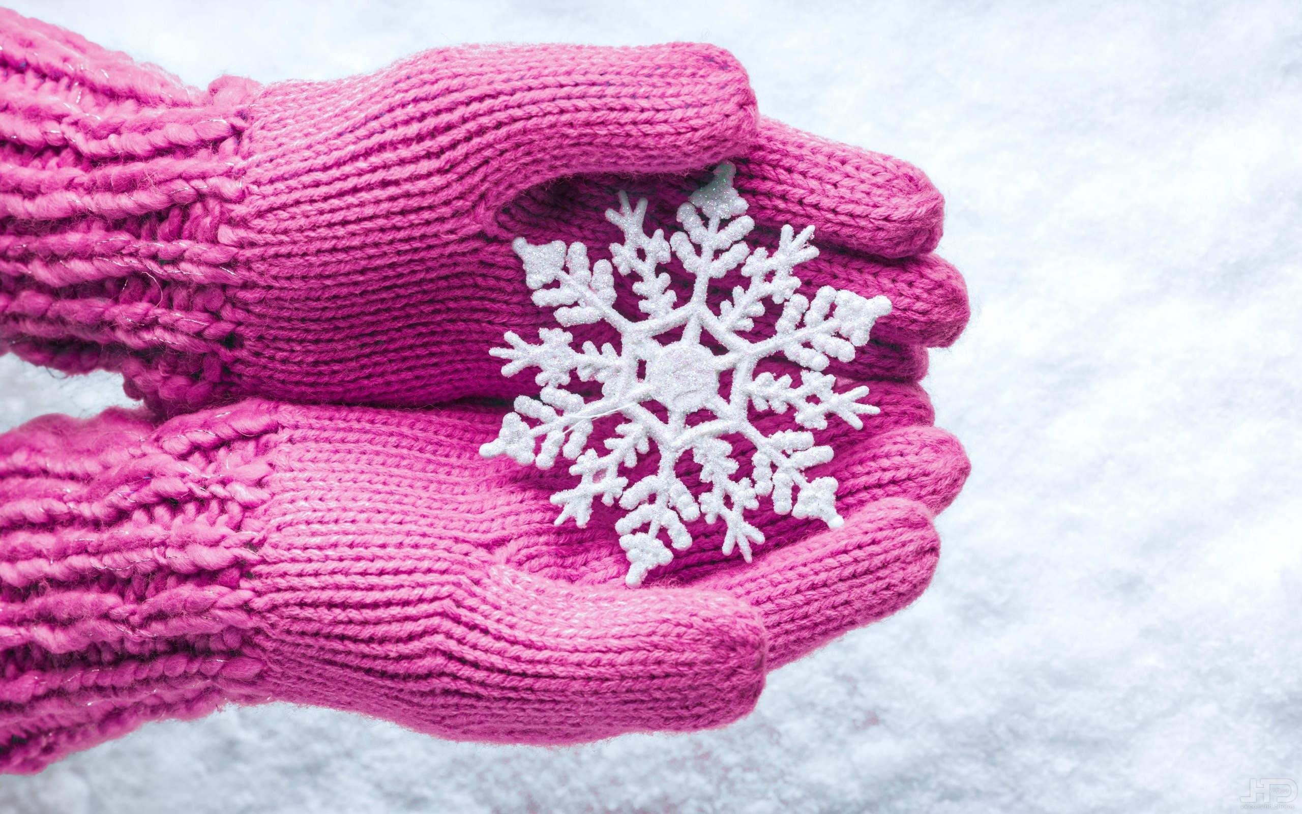 Pink knitted gloves holding a snowflake HD Wallpaper
