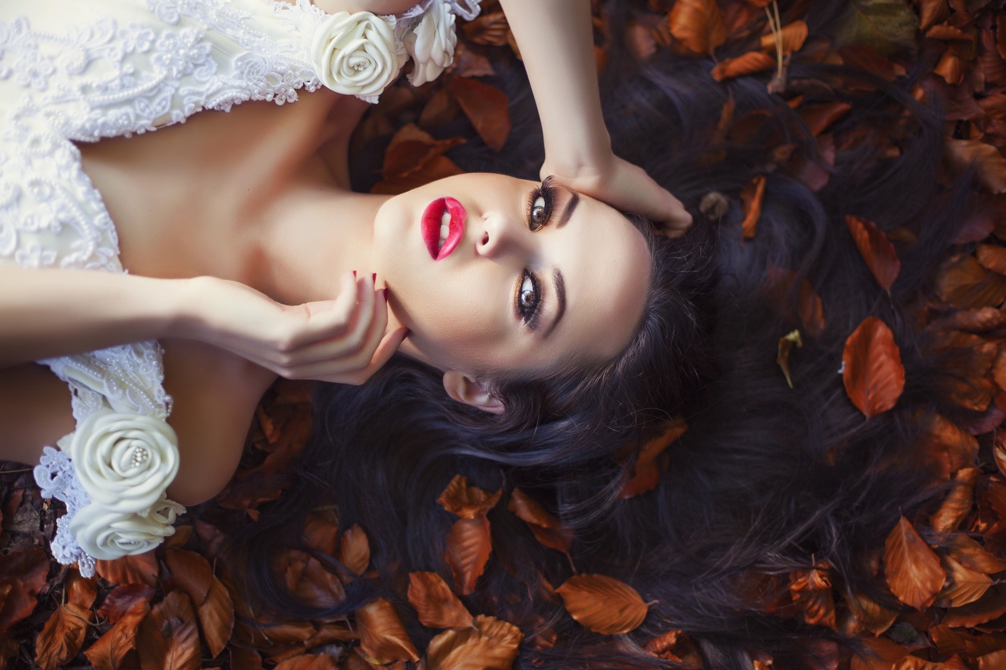 Woman in white dress lying on autumn leaves HD Wallpaper