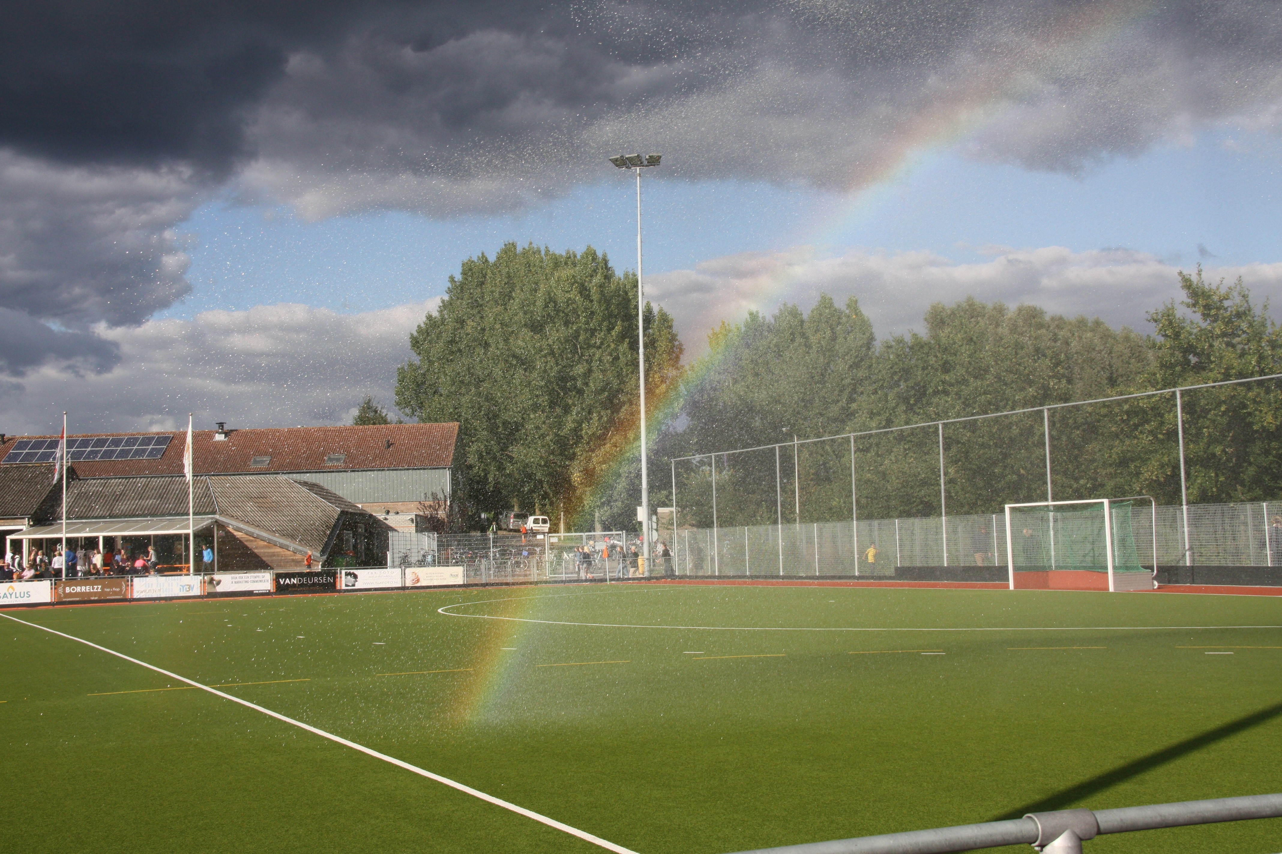Field hockey field with rainbow and stadium HD Wallpaper