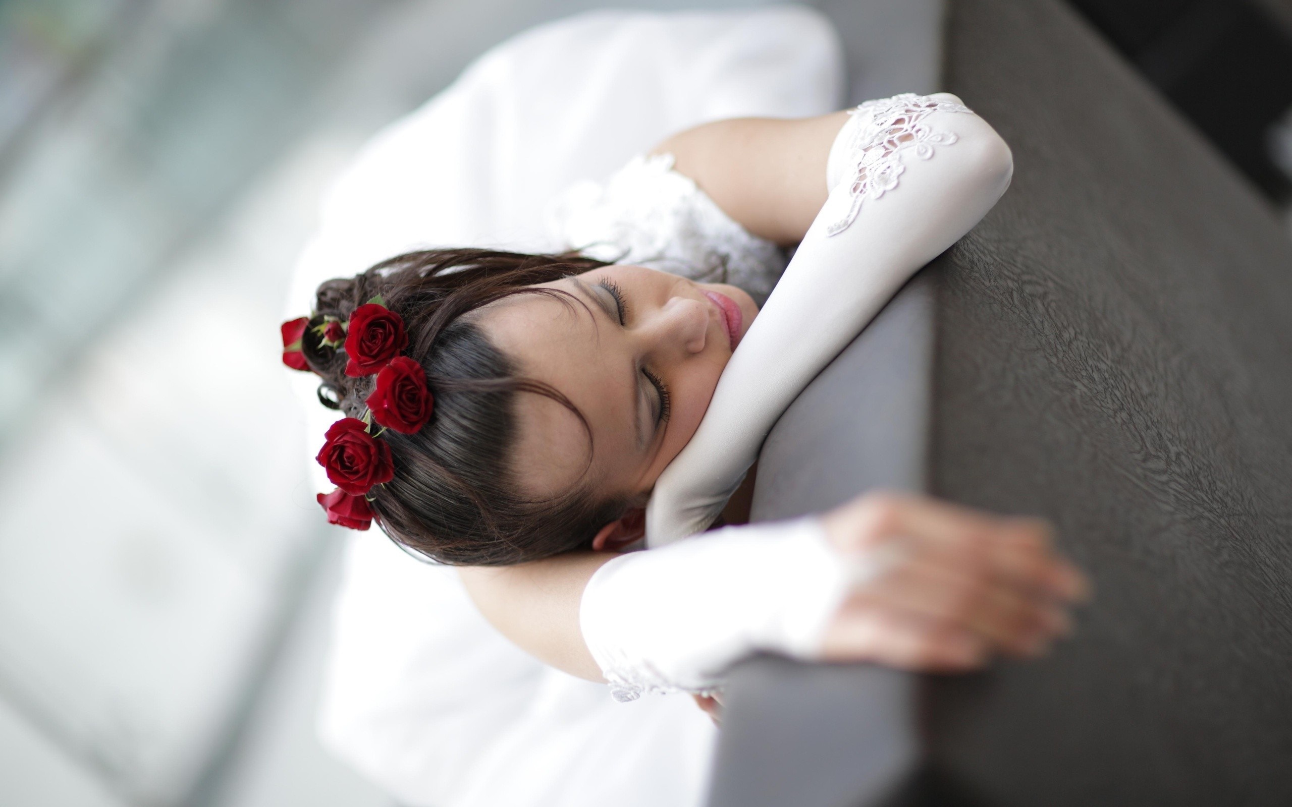 Bride with red roses in hair resting head on arm HD Wallpaper
