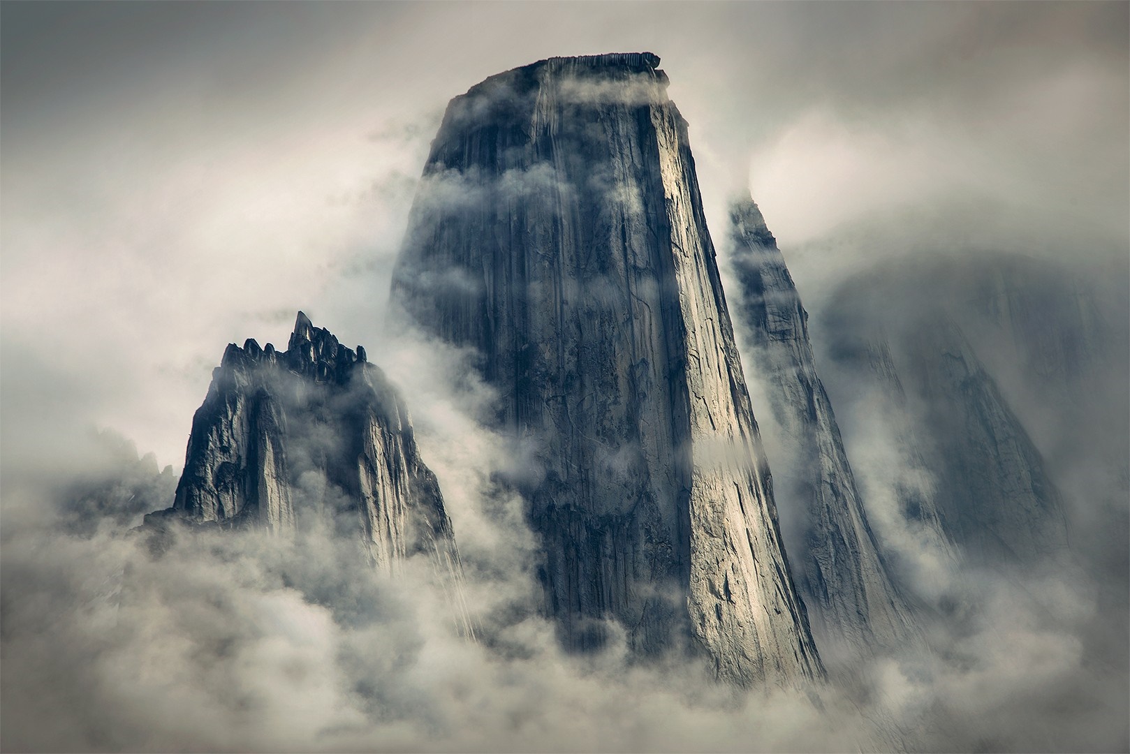 Misty mountains with sunlight on cliffs HD Wallpaper