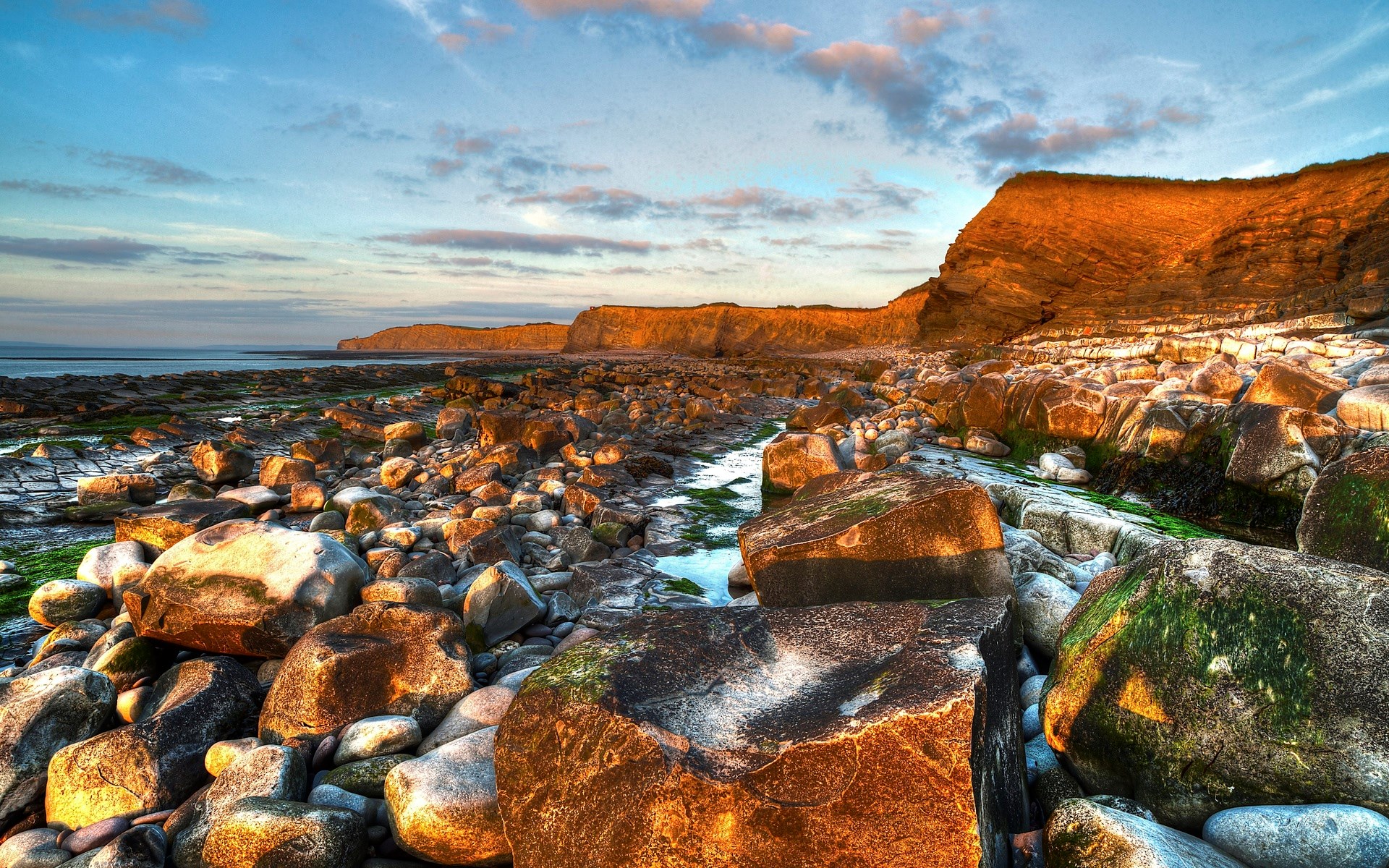 Rocky coastline with cliffs and ocean at sunset HD Wallpaper