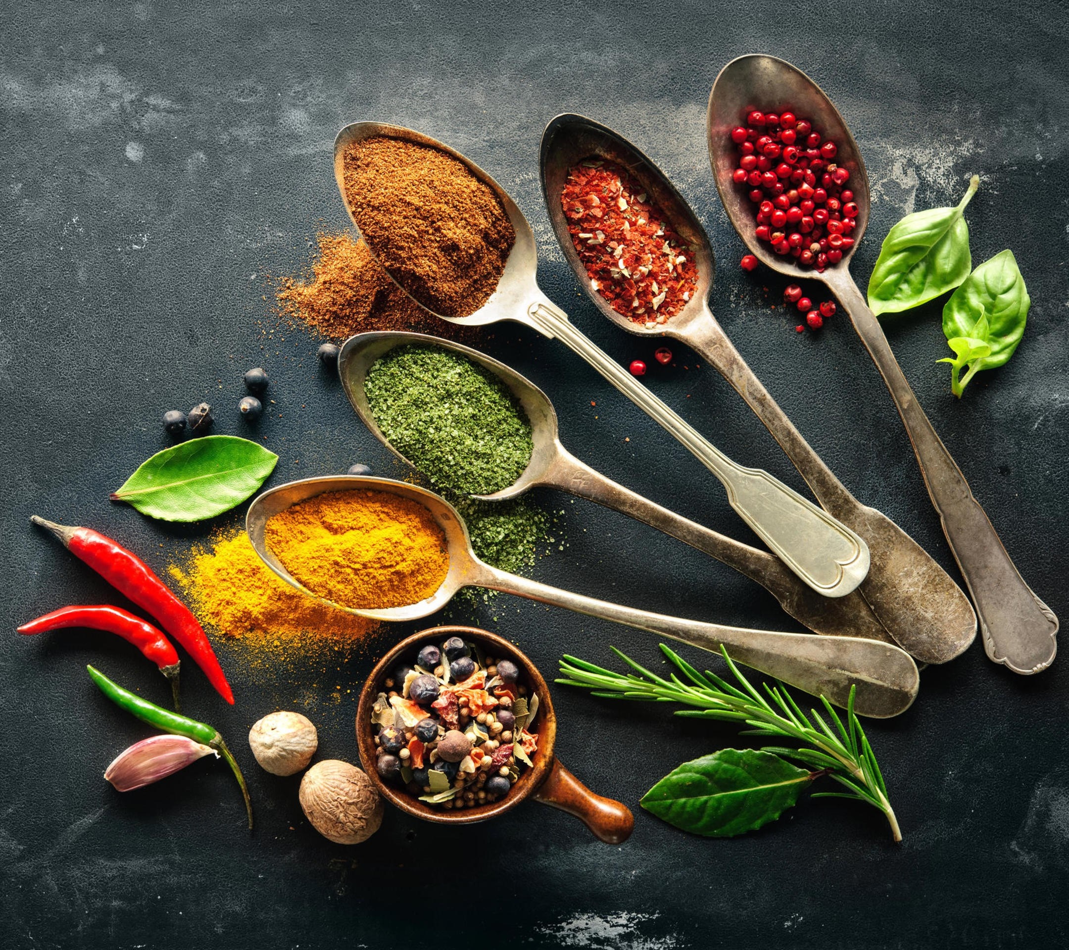 Assortment of spices and herbs in spoons and bowl HD Wallpaper